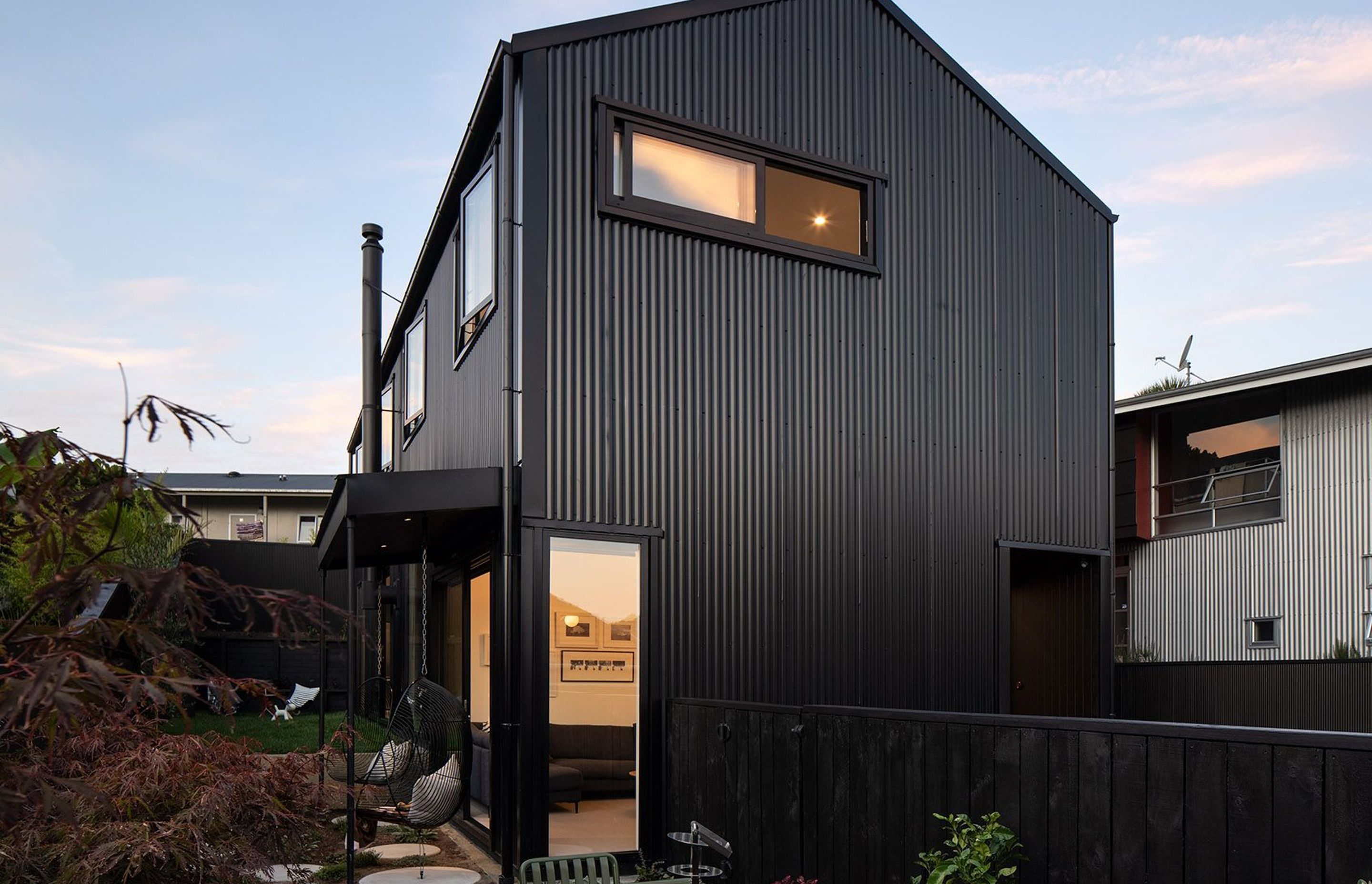 Clad in black corrugate, the front elevation casts a striking gabled form within its tight Grey Lynn site.