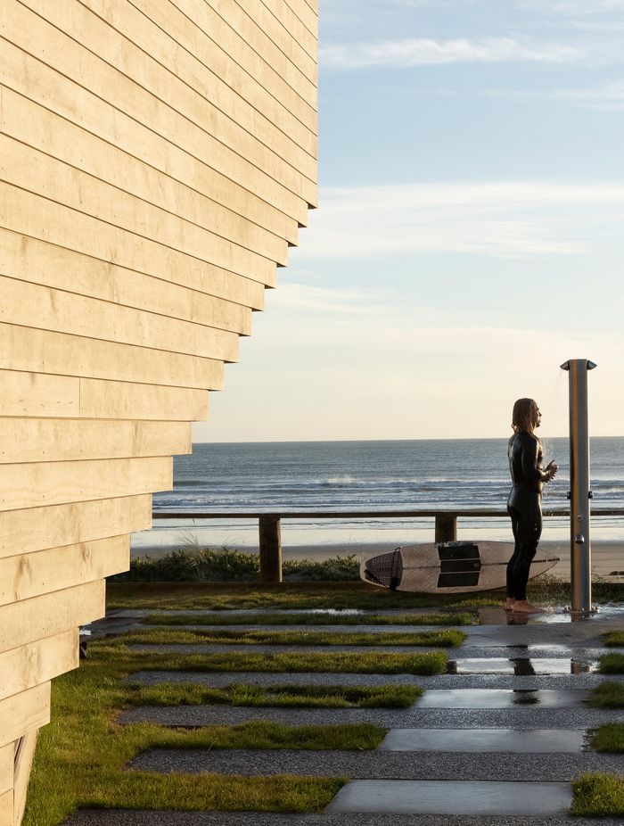 A surfer enjoys an outdoor shower at the front of the building. Ken says the beautiful new building hasn't suffered any tagging, and he often sees members of the community gather outside for morning coffee to interact and enjoy the facility.