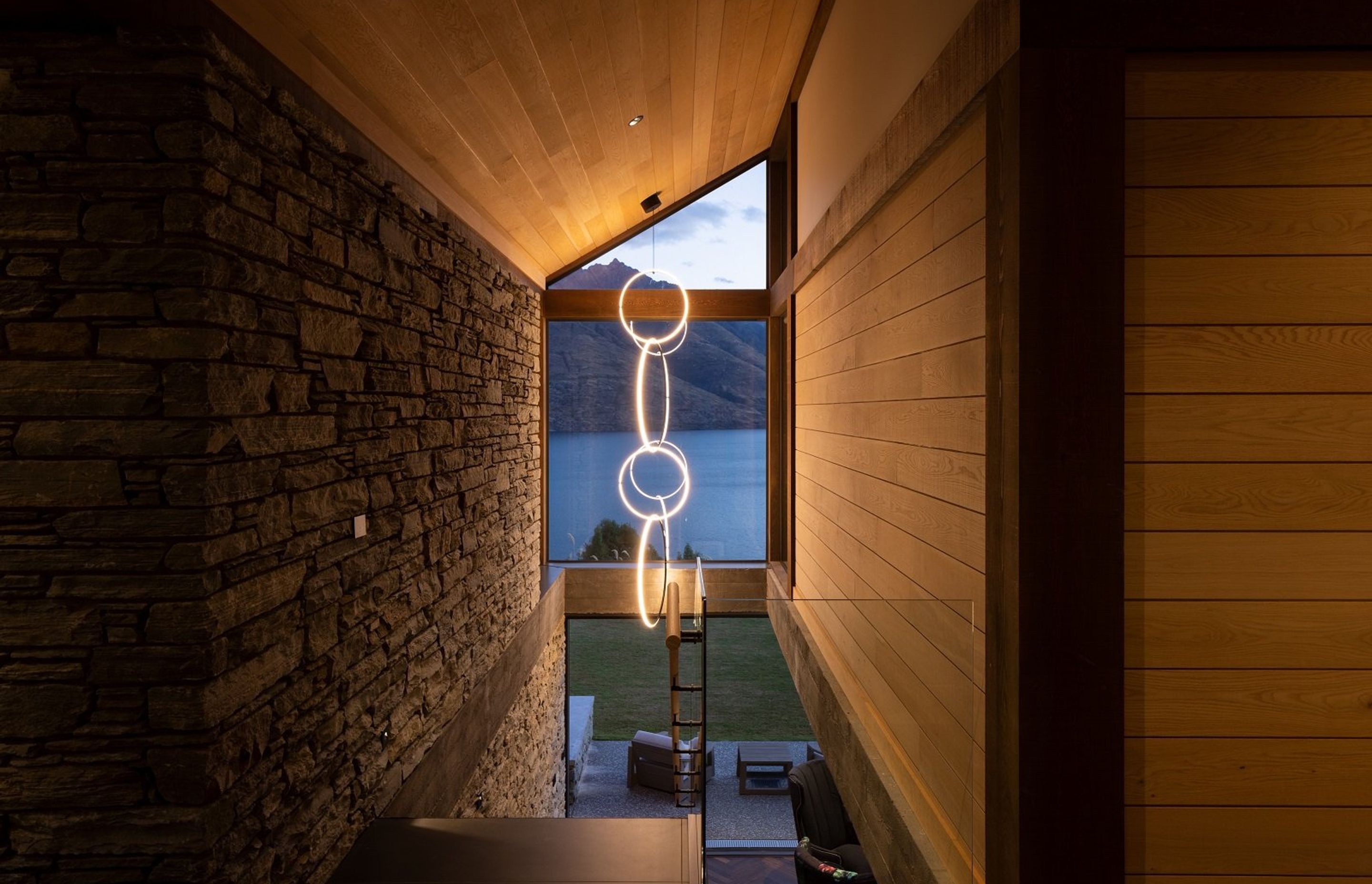 The sculptural Flos pendant light in the stairwell draws your eye out to the view, directly as you enter the main foyer.