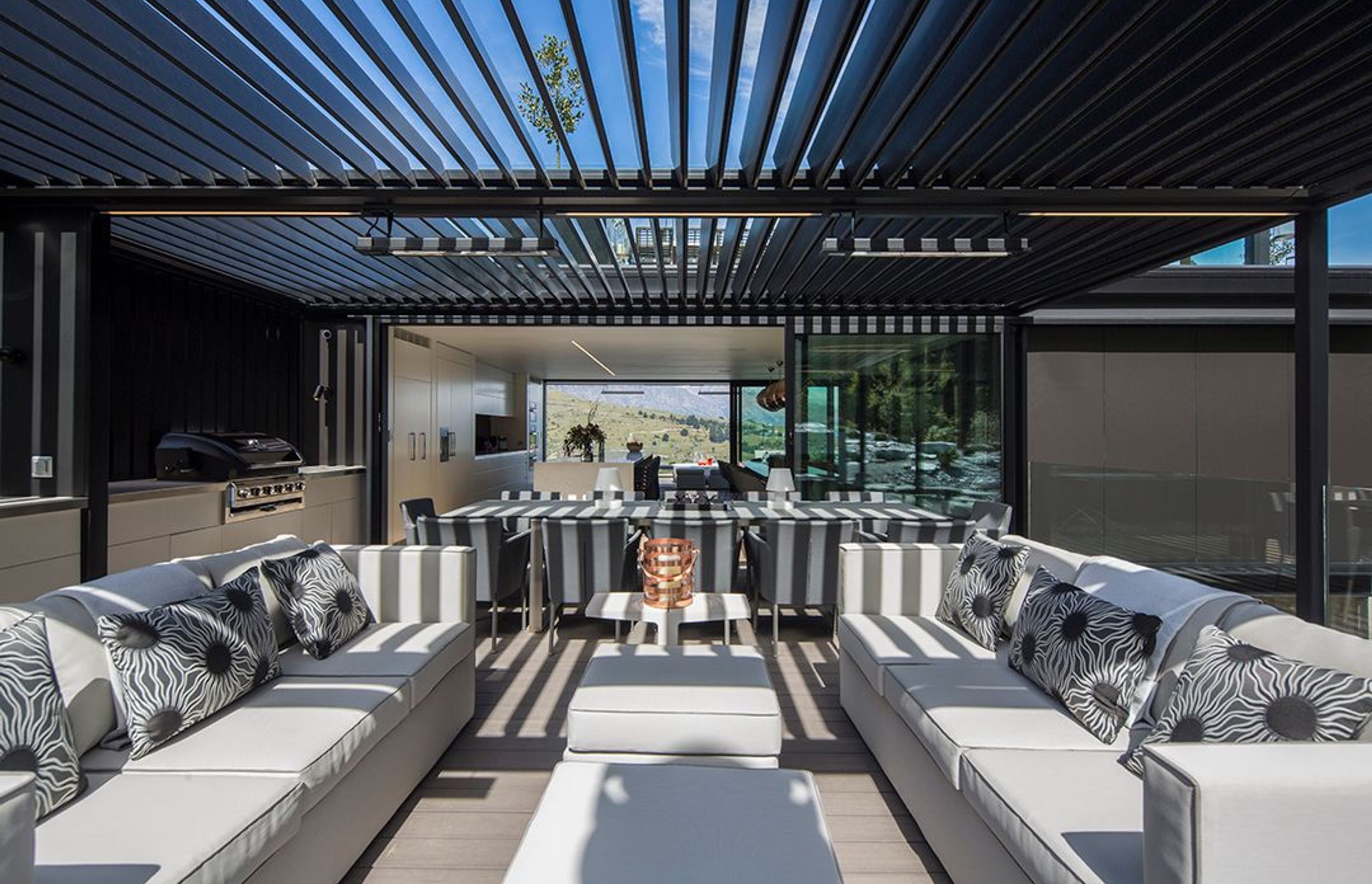 The outdoor lounge area and kitchen is covered with adjustable louvres for shading. Stacker sliding doors allow a view shaft through the interior to the landscape on the opposite side.
