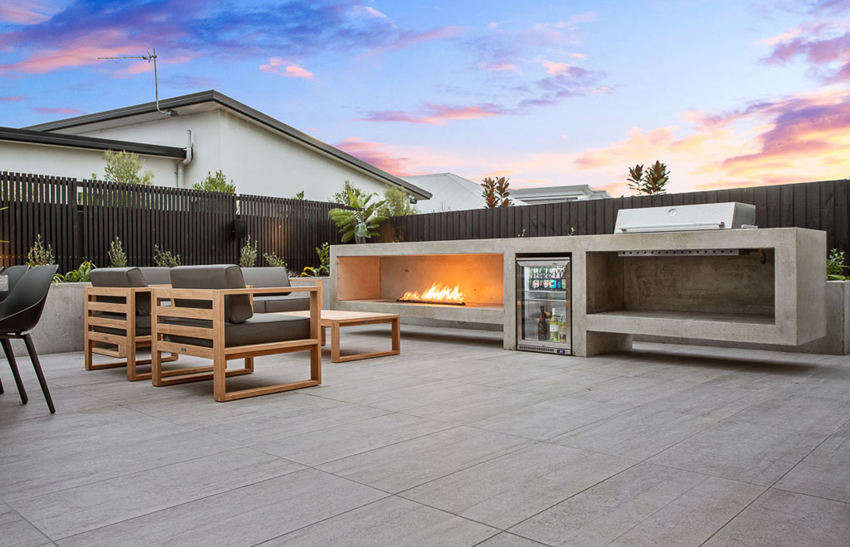 The backyard barbeque space with built-in fridge and gas fire.
