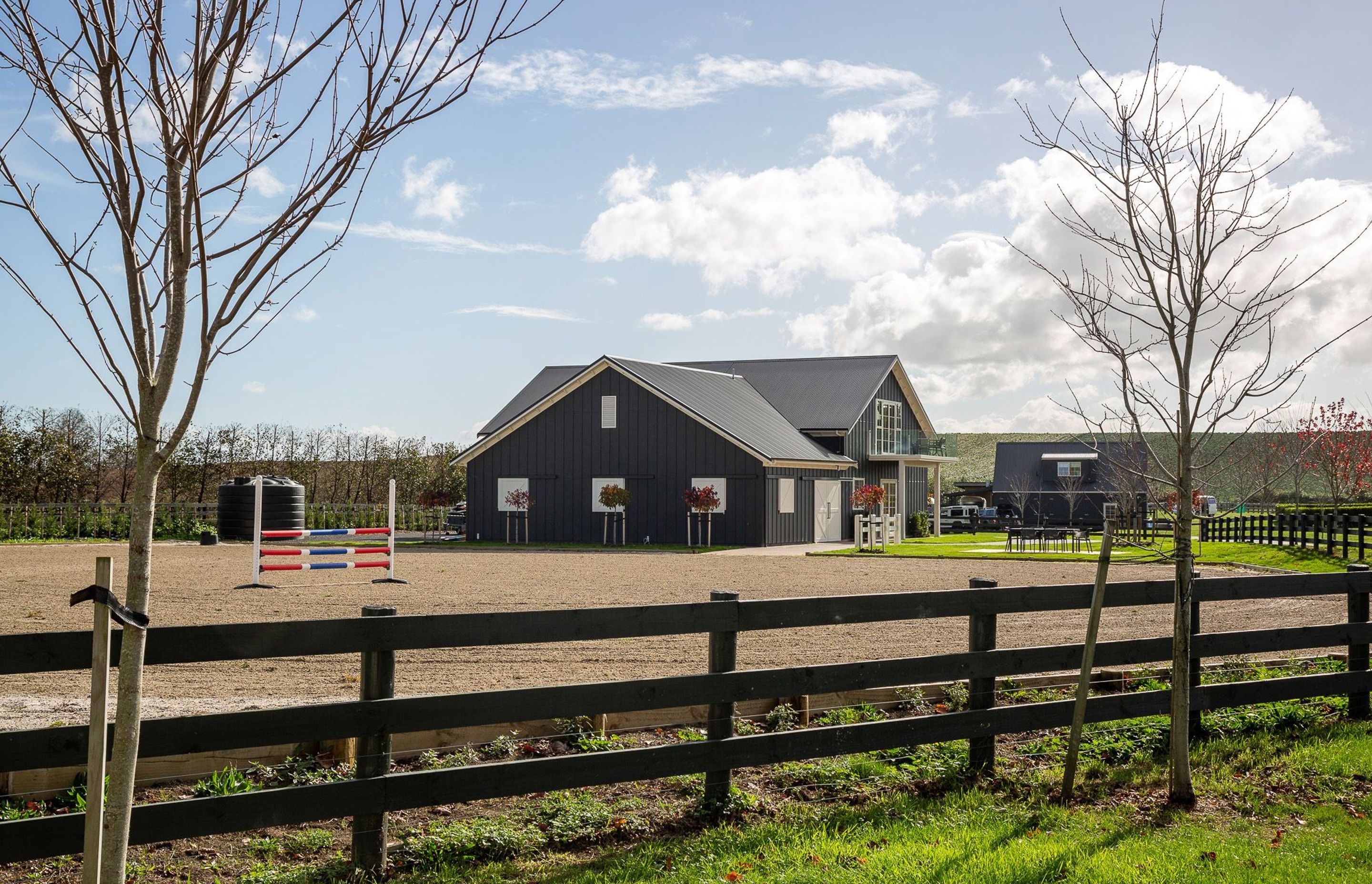 Set within a rural landscape within the Bombay Hills, south of Auckland, the barn is linked to a sand and shell horse arena.