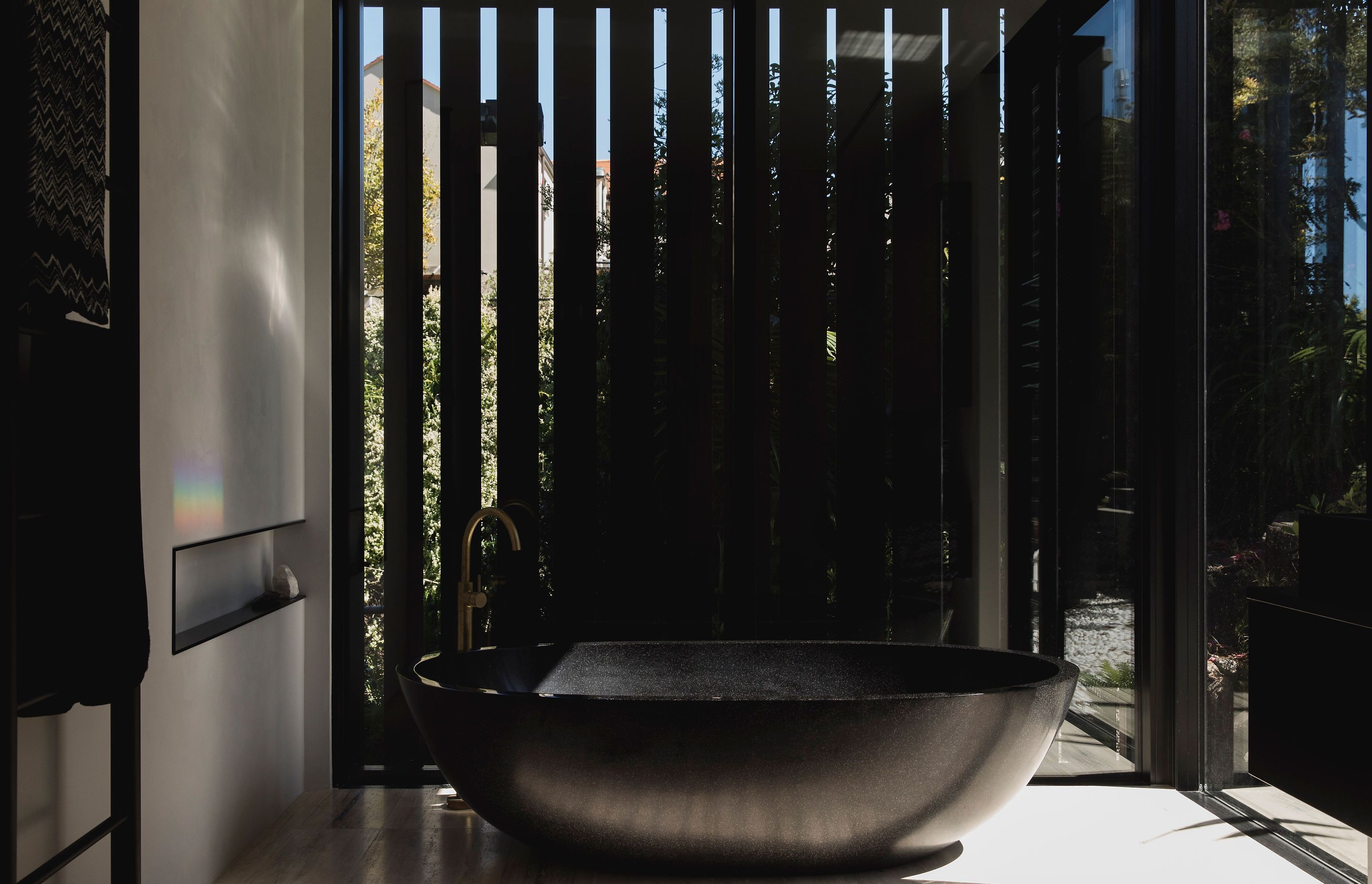 The architects really love designing bathrooms that are really intenses spaces, including this en suite bathroom with curvaceous freestanding black bath.