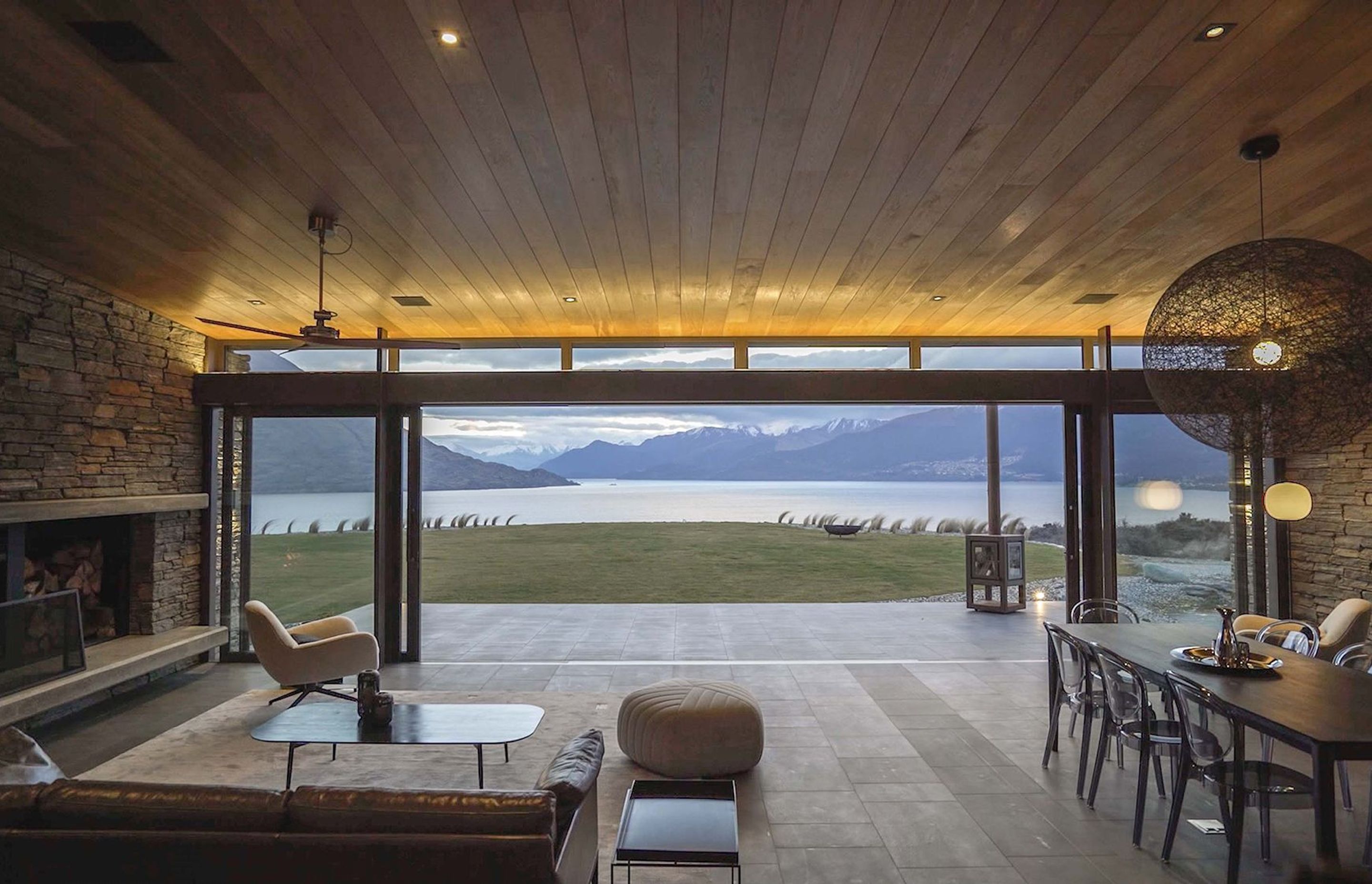 The living/dining area looks straight out over the lake and mountains. Photograph: ArchiPro.