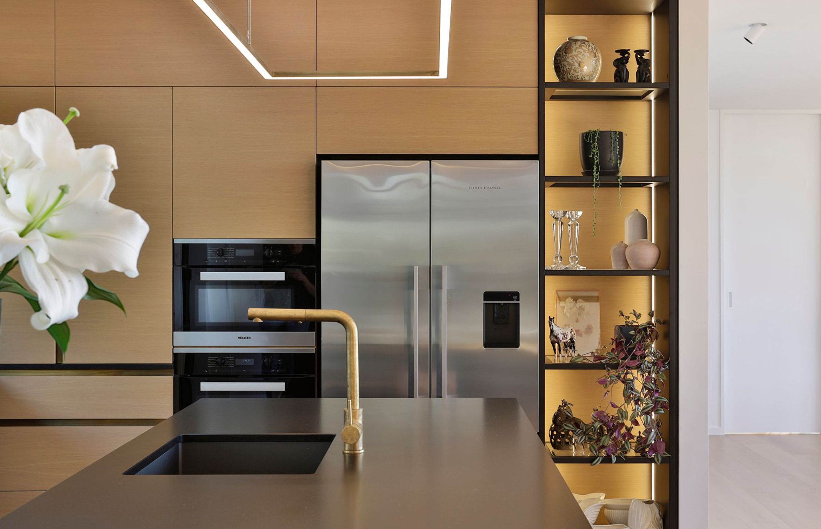 Golden hues mix beautifully with black and metallic finishes in the kitchen.