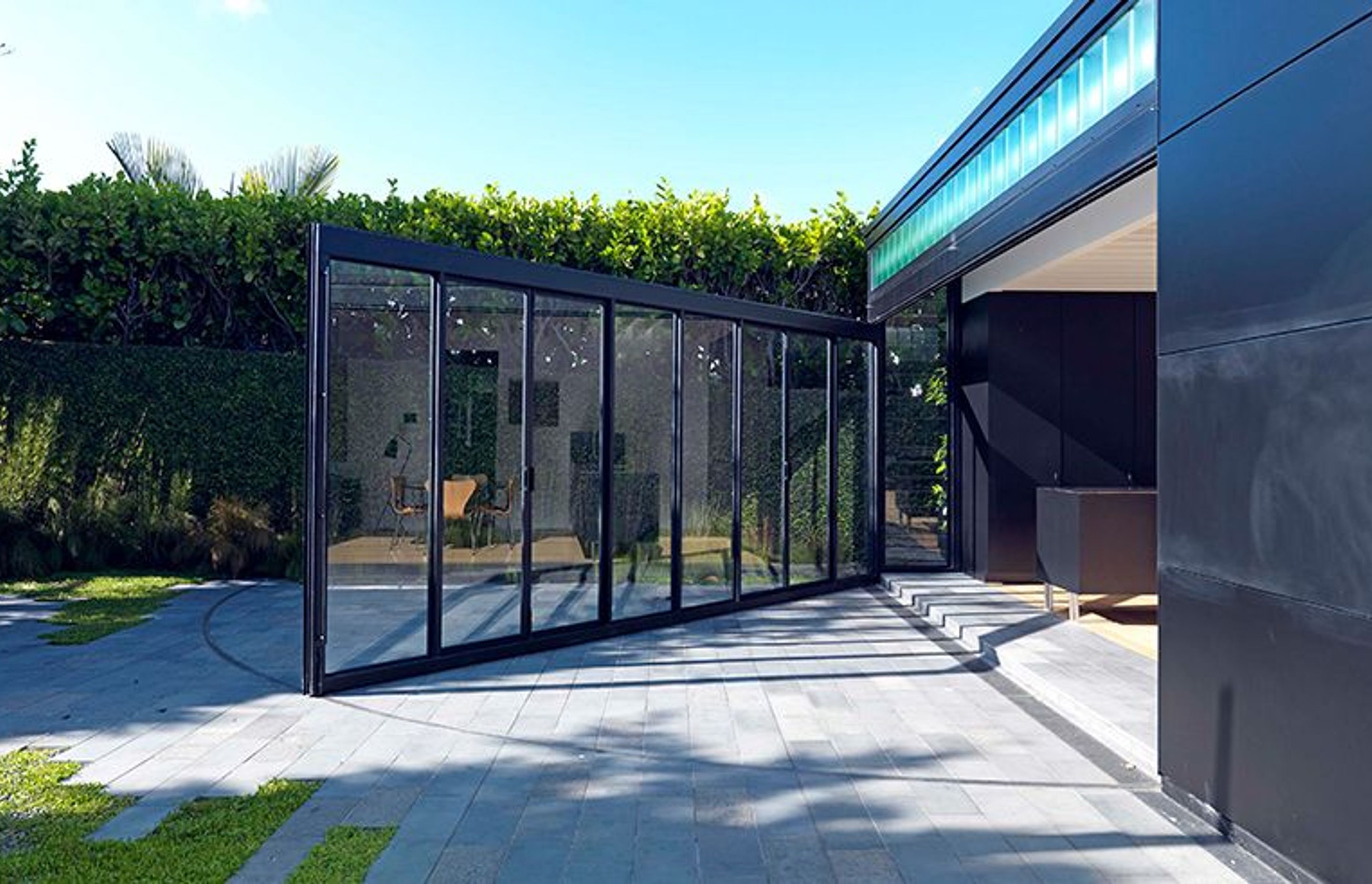 The opening wall of steel joinery and glass incorporates two pairs of French doors that can be used independently when the wall is closed.