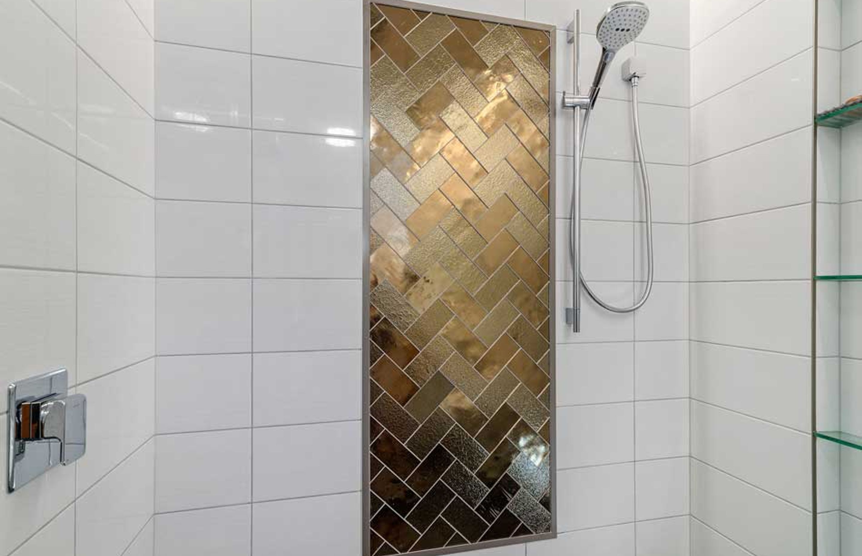 These bronze glass tiles are definitely a feature inside this double shower - and the herringbone pattern adds interest