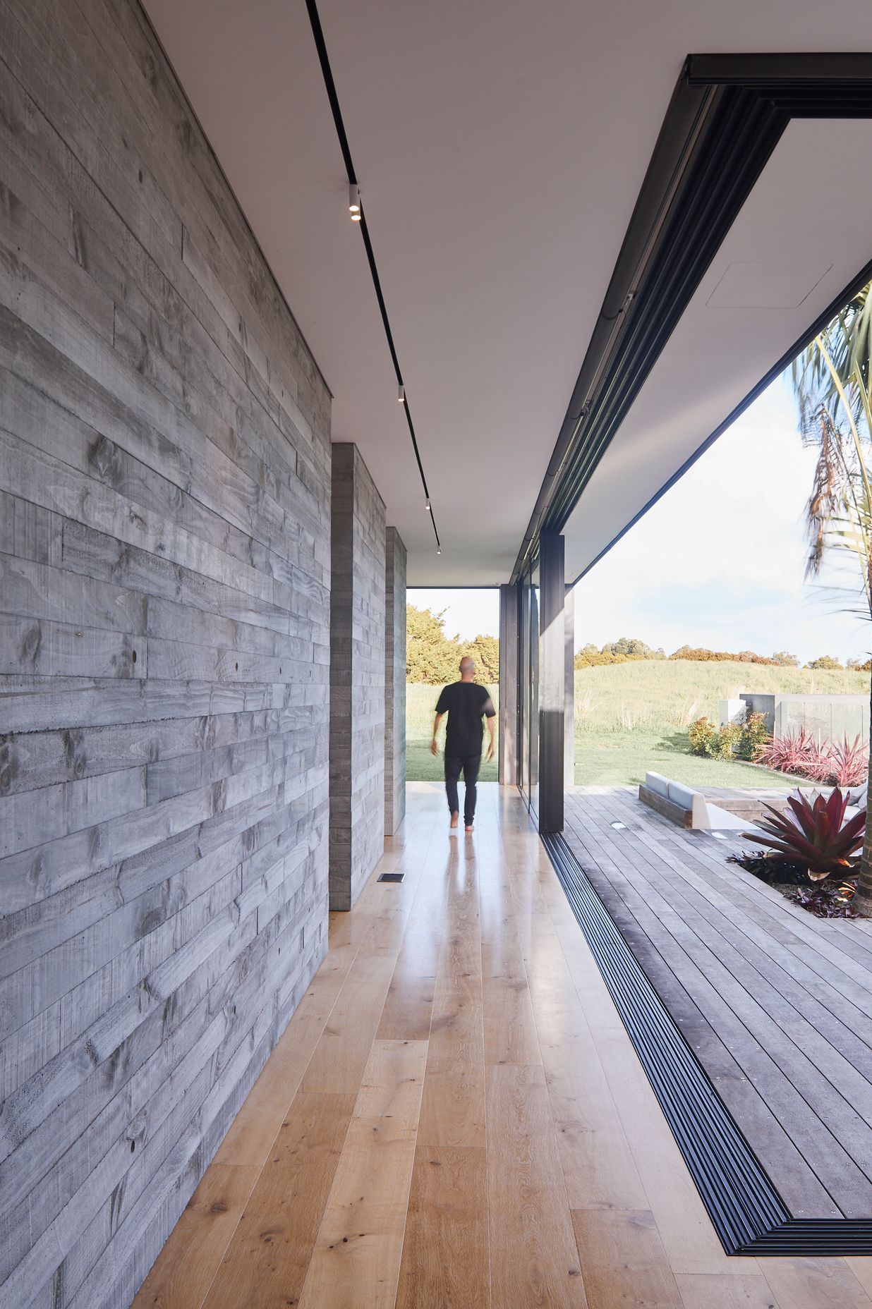 Full-width sliding doors help blur the lines between indoors and out, further enhanced by the textural nature of the chosen materials.