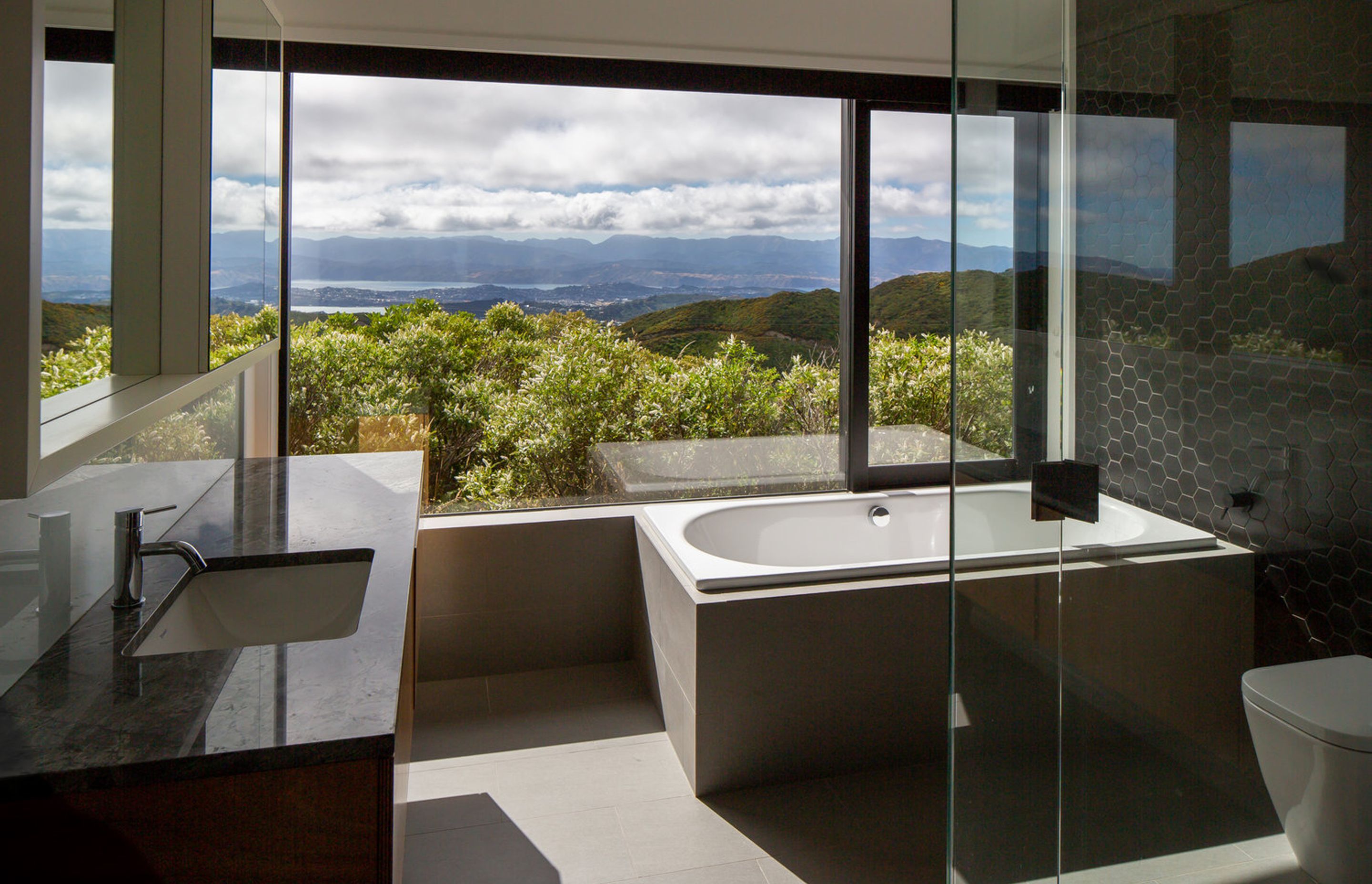 The owners enjoy sitting in this bath surrounded by the fringe of bush and Wellington city is just 10 minutes drive away.