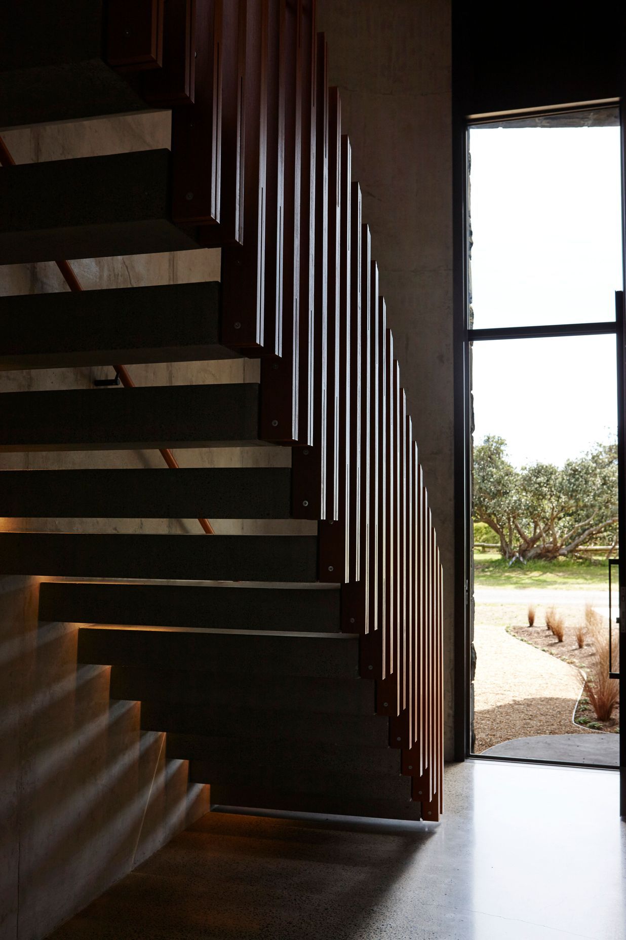 The cantilevered staircase mimics the first floor that juts out over the entry, establishing the interior as an arrangement of complex forms.