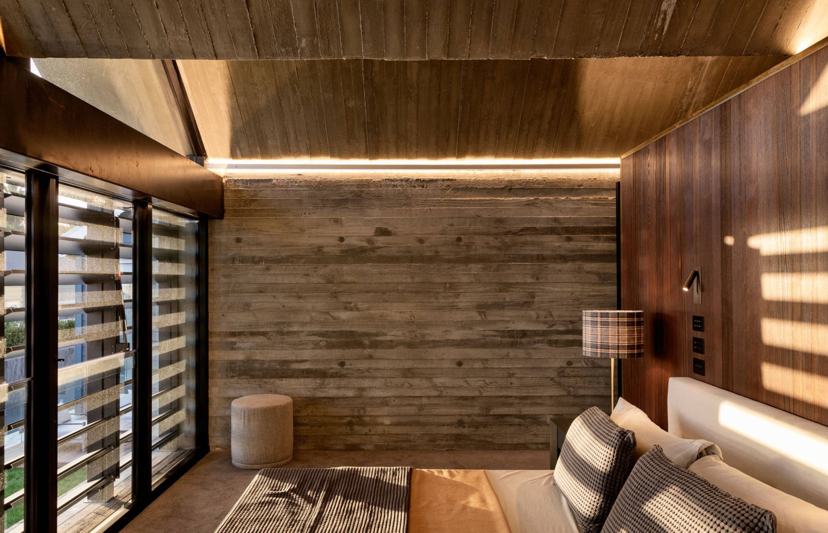 The guest suite enjoys the striking zigzag concrete ceiling, along with walls in weatherboard-shuttere concrete and timber panelling.