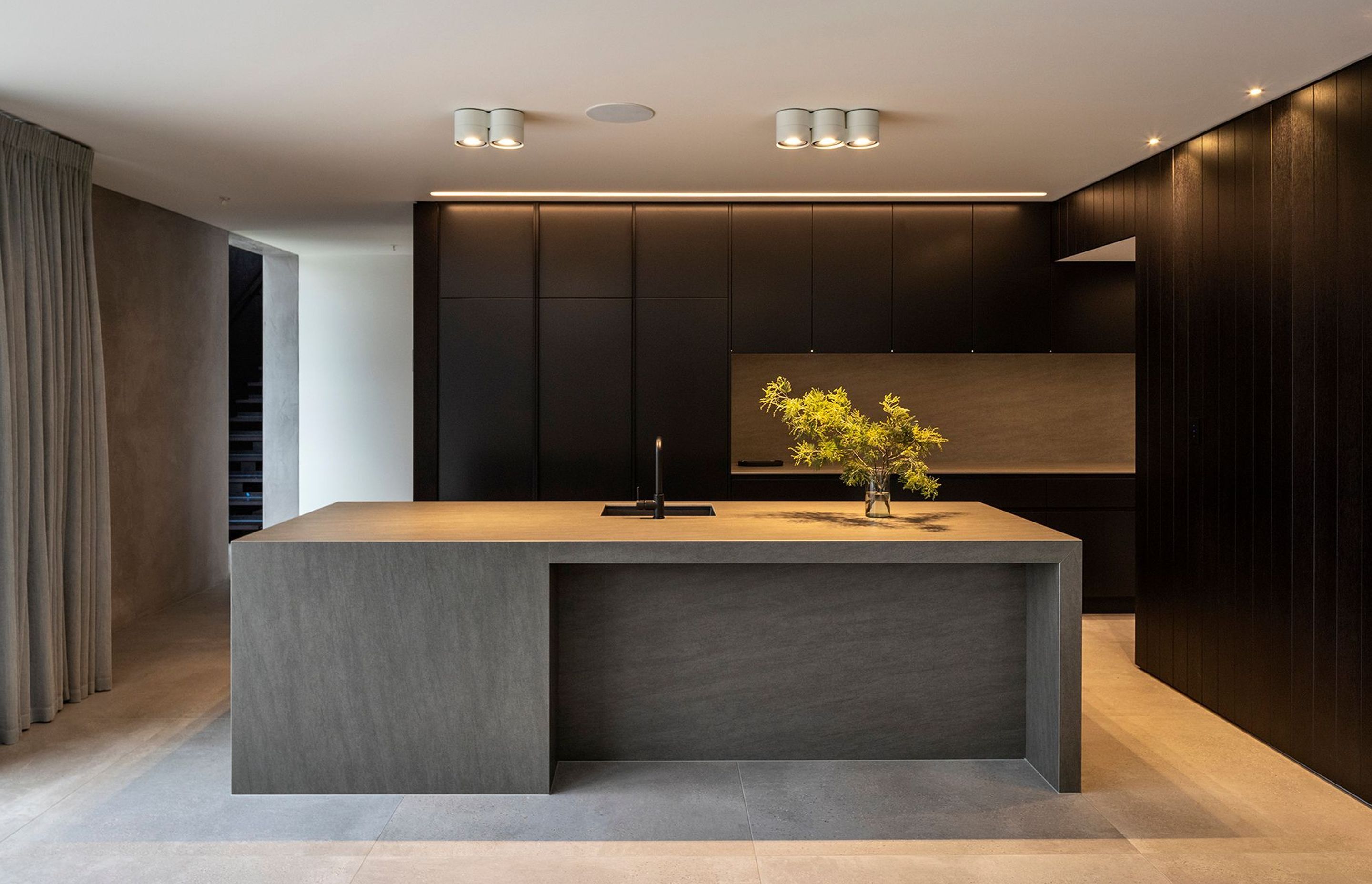 The kitchen is carefully detailed with the functional cooking area concealed in a separate annex, allowing the occupants to enjoy the primary space without clutter.