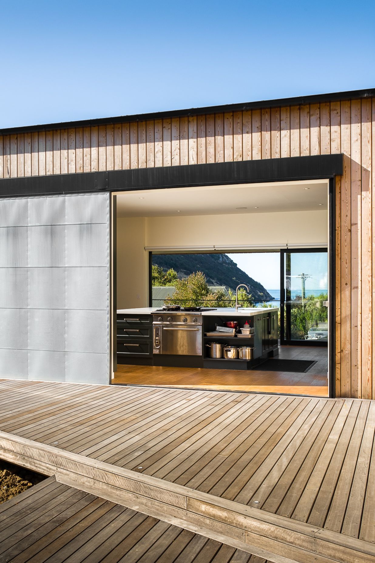 The industrial door opens up the 'evening' deck to a view of the ocean.