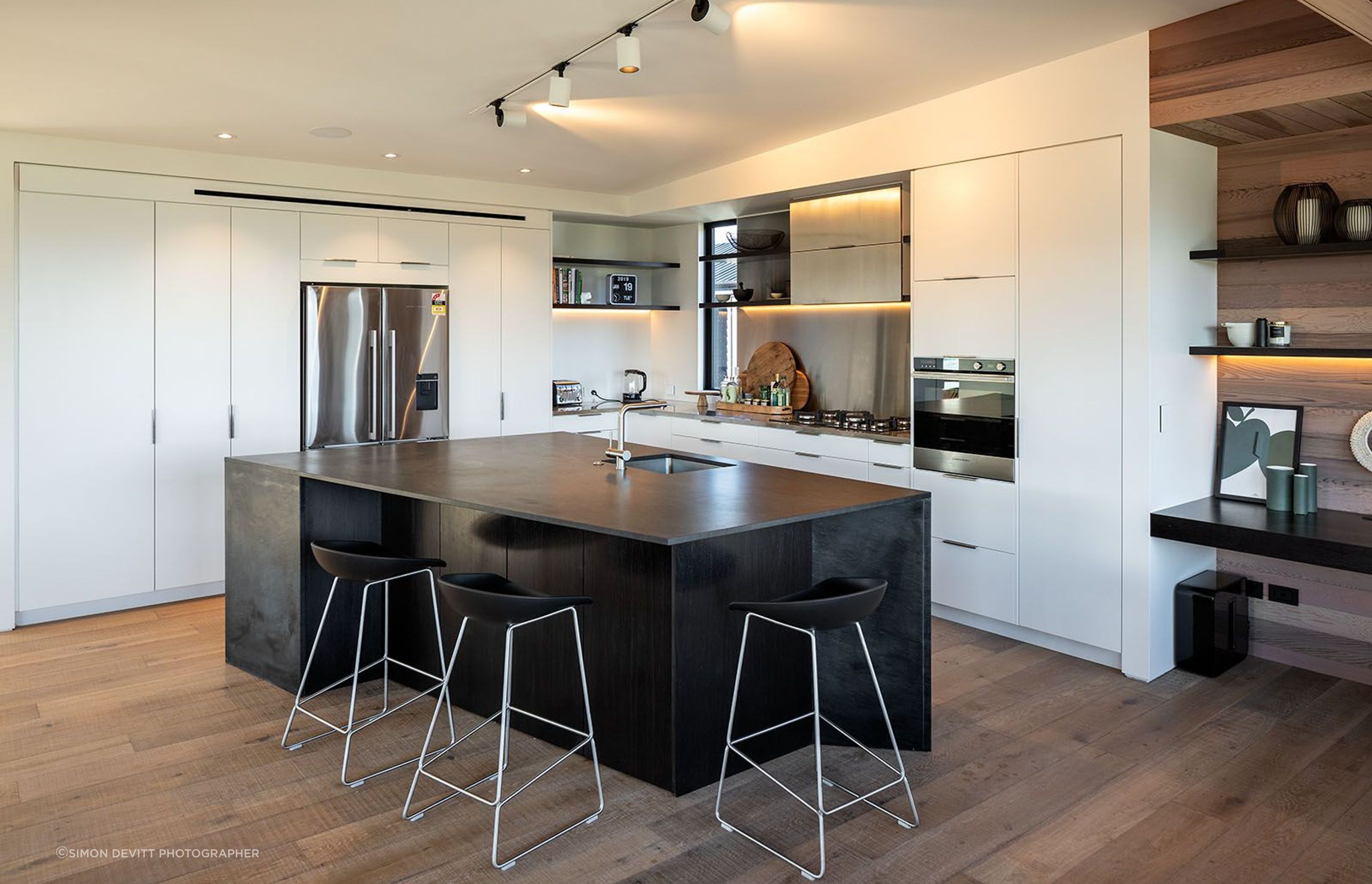 A large black island in the kitchen is a sculptural form that mimics the shape of the building.