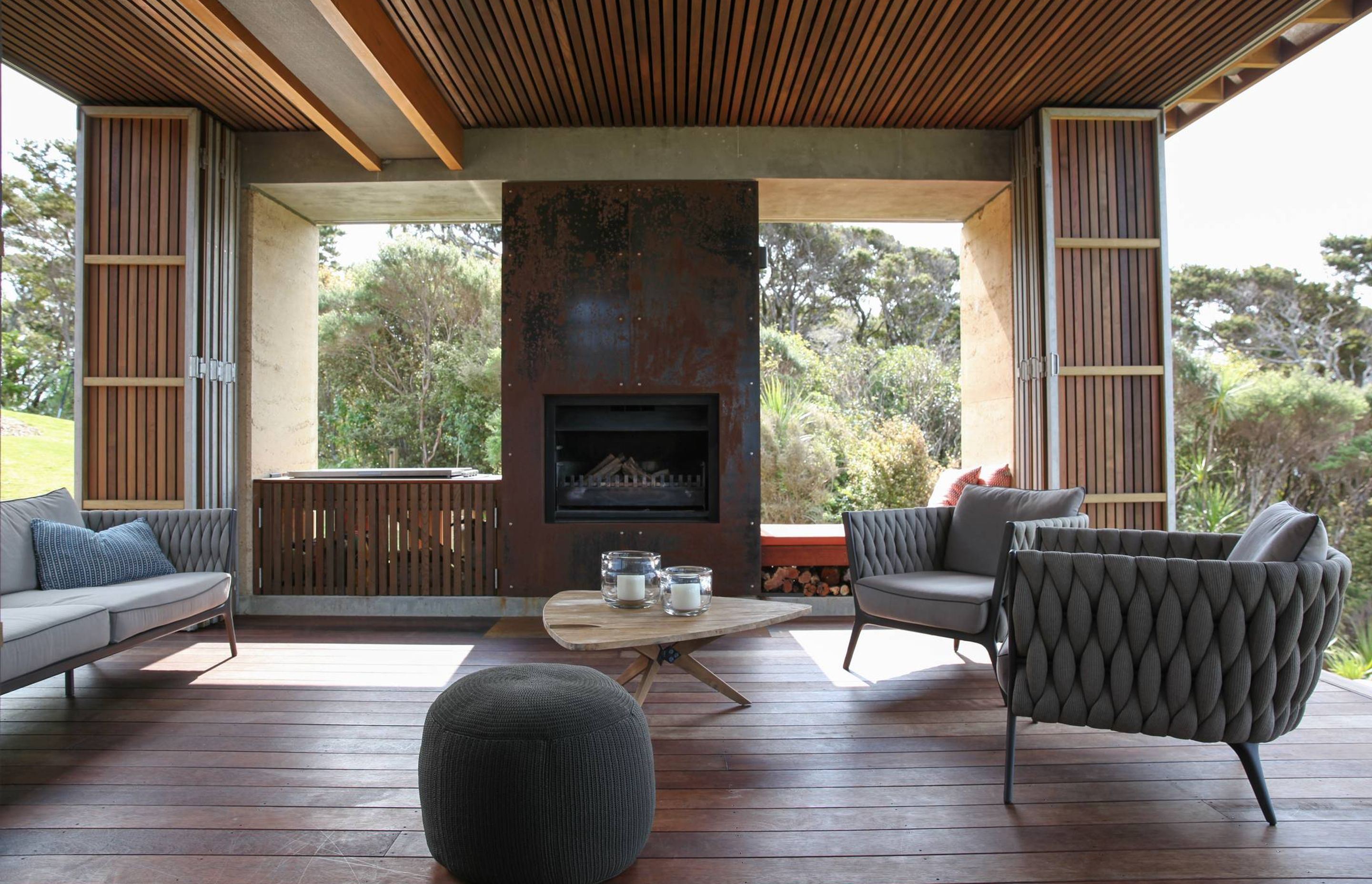 The outdoor room features cedar rainscreens, wide-plank spotted gum flooring and an open wood fire with metal surroundls. Photograph by Jackie Meiring.