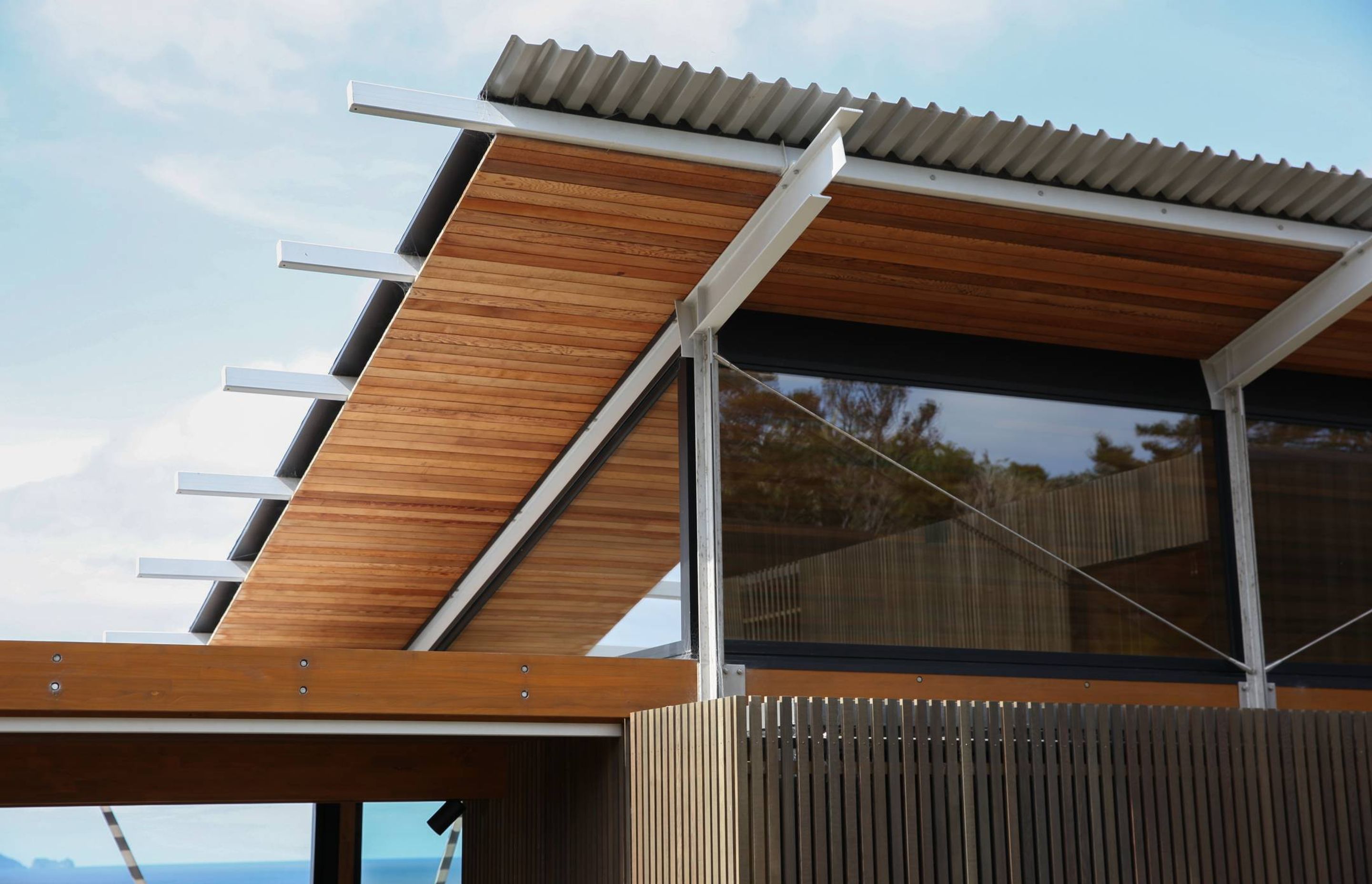 A detail showing the cedar-clad soffit and the steel structure with cable ties providing additional bracing. 