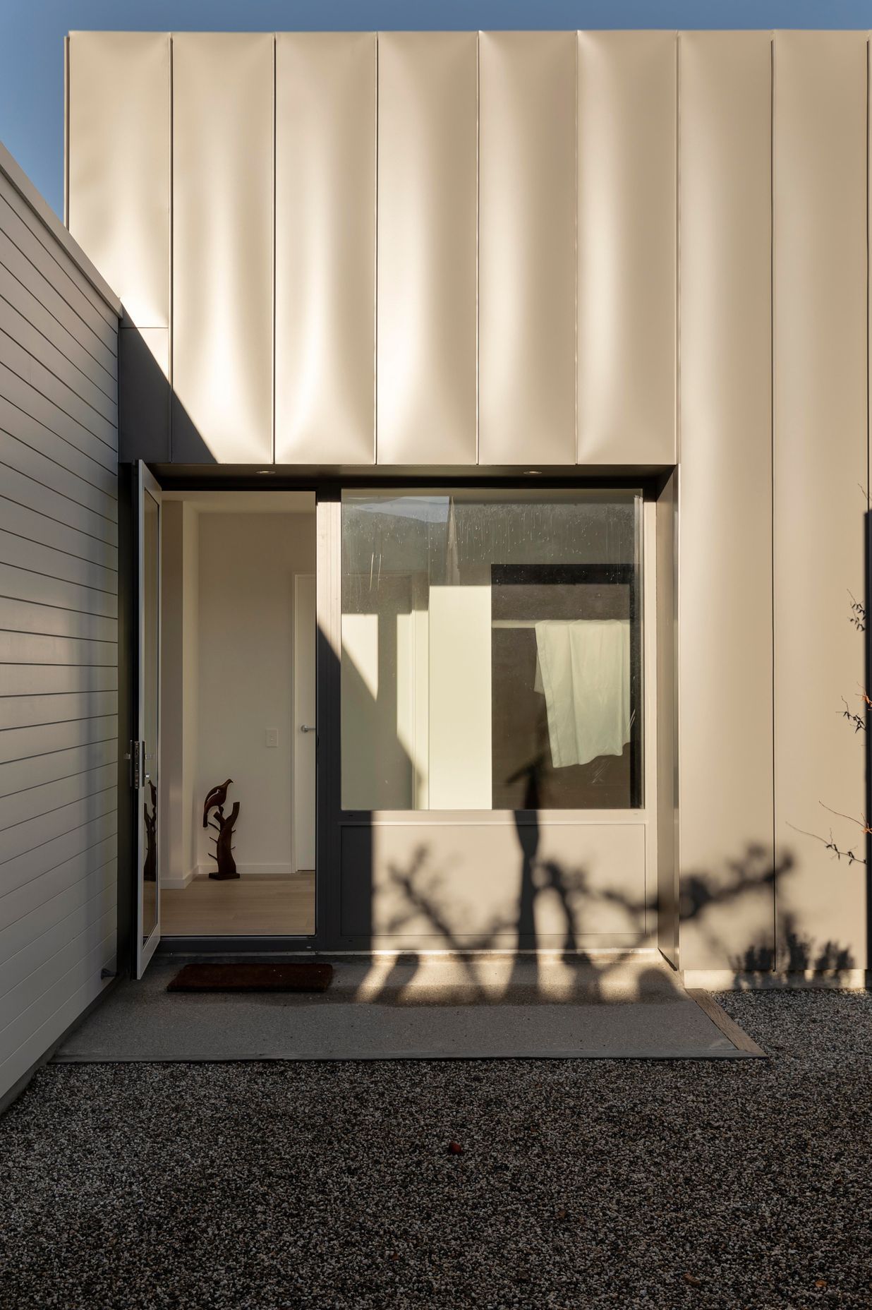 The intersection between the white and grey parts of the house is seamless and throws interesting shadows across the building.