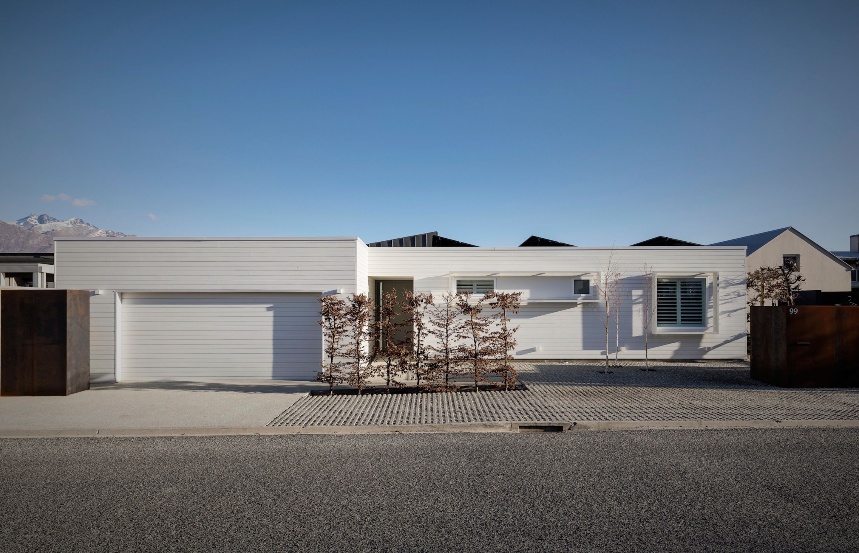 The street frontage blends into the natural environment and references the snowy peaks of the nearby Remarkables mountain range.