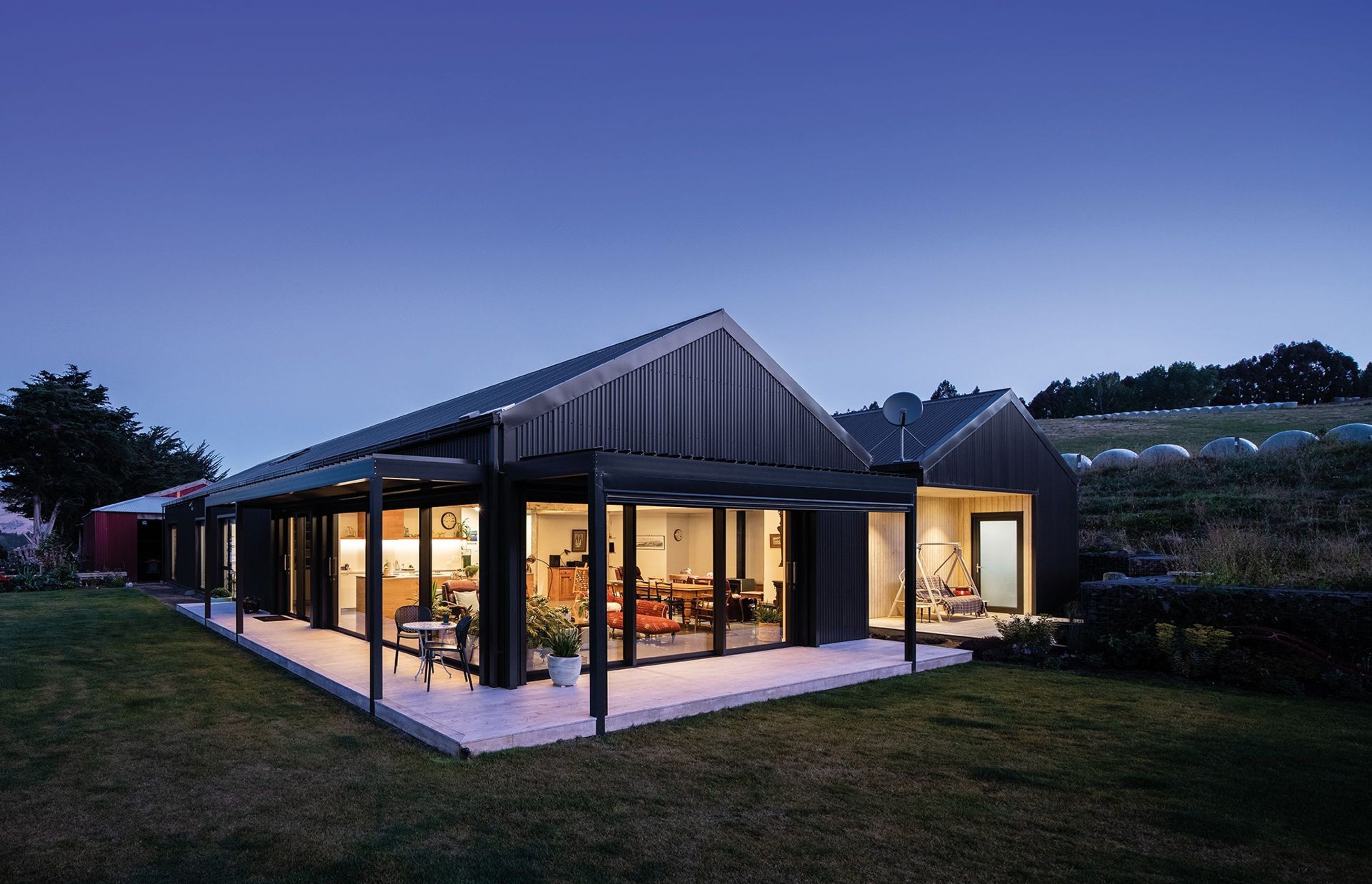 The new home provides an open, flexible living environment with a seamless connection to the surroundings. A new structure adjacent to the shed contains the garage and a large storage area.