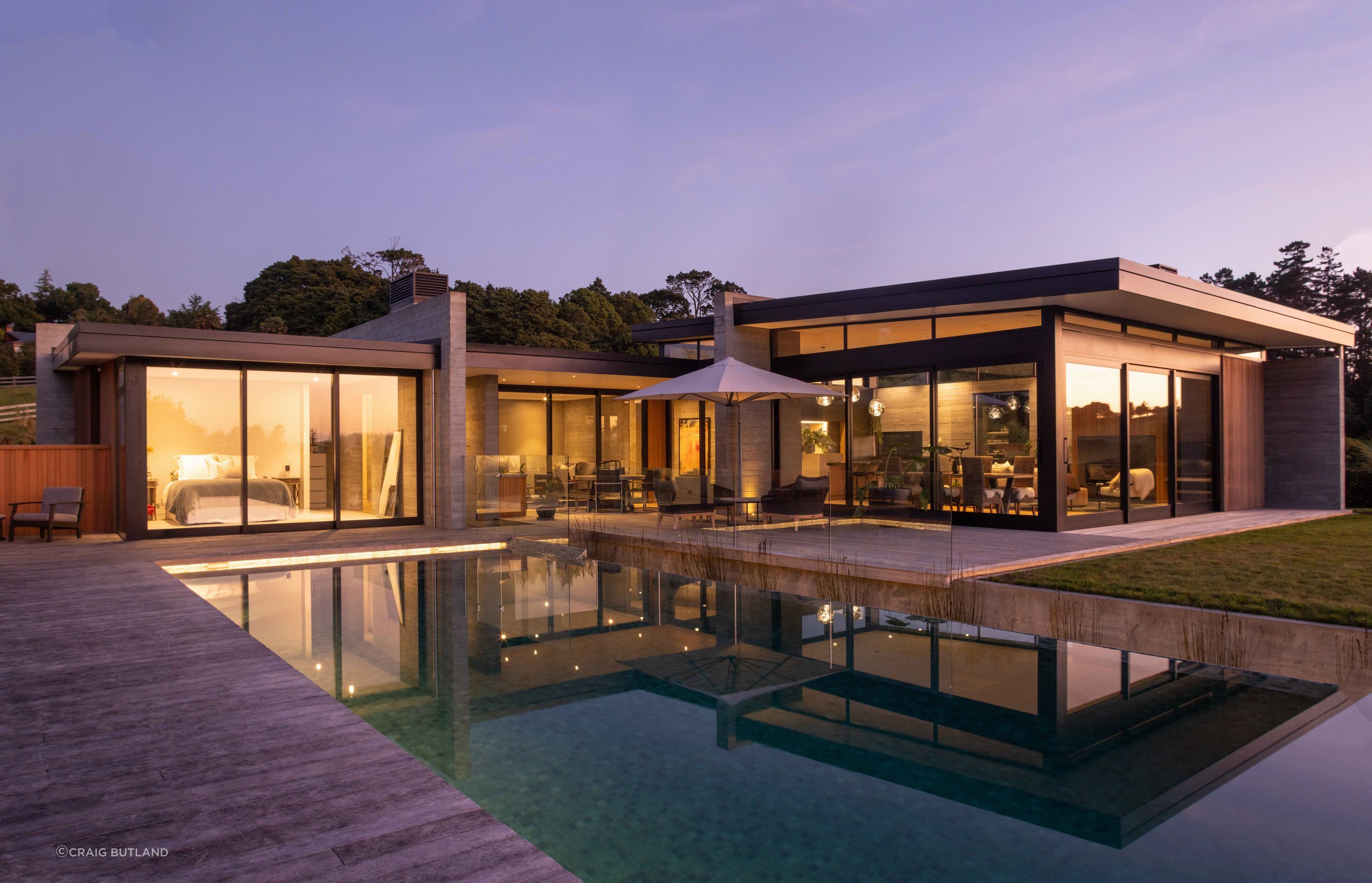 Large expanses of glass allow the glow from the interior to spill out over the exterior entertaining area and pool.