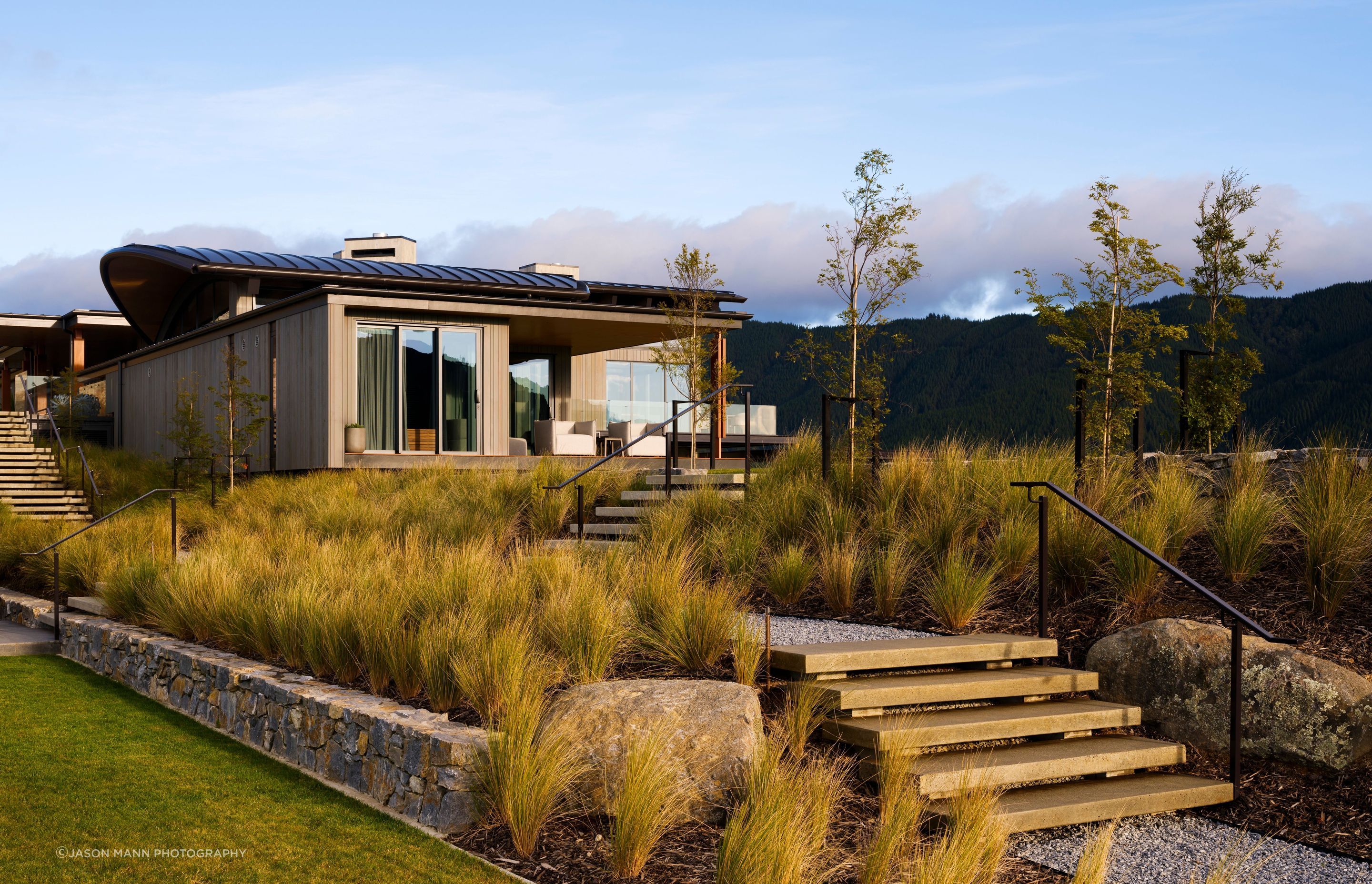 Due to the typology and elevation of the site, as well as the climate, the landscaping features a theme of regeneration with a palette of native New Zealand plants as the backdrop.