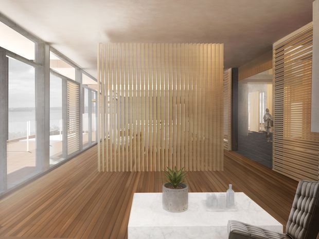 Warm contemporary interior lounge or living area with floor-to-ceiling glazing overlooking water, a timber floor, and a sculptural vertical timber-slat privacy screen dividing the space. Horizontal timber louvres cover the glazing and wall openings, while a white stone coffee table, upholstered armchairs, and a potted plant create a refined, natural palette.
