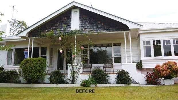 Front exterior view of a traditional single-storey house with white weatherboard cladding, a prominent gabled porch, dark shingle gable infill, white posts and trim, timber-framed windows, and landscaped shrubs along the facade. The image is labelled “BEFORE.”