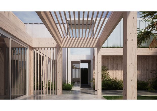 A contemporary courtyard entrance framed by a light timber pergola and vertical timber screens. The space features pale textured masonry walls, large glazed openings, a dark entry door, a polished hardscape floor, and landscaped planting around a narrow water feature. The open slatted overhead structure creates strong linear shadows and a bright, airy architectural composition.