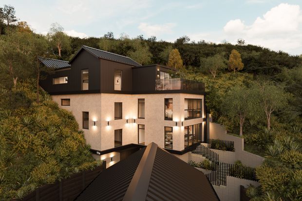 A contemporary multi-level residential home set into a densely vegetated, sloping site. The building combines a light rendered lower volume with a dark upper storey, steep pitched metal roofs, expansive glazing, balconies and layered terraces. Warm exterior lighting highlights the facade and landscaped approach, while surrounding trees and planting create a secluded bush setting.