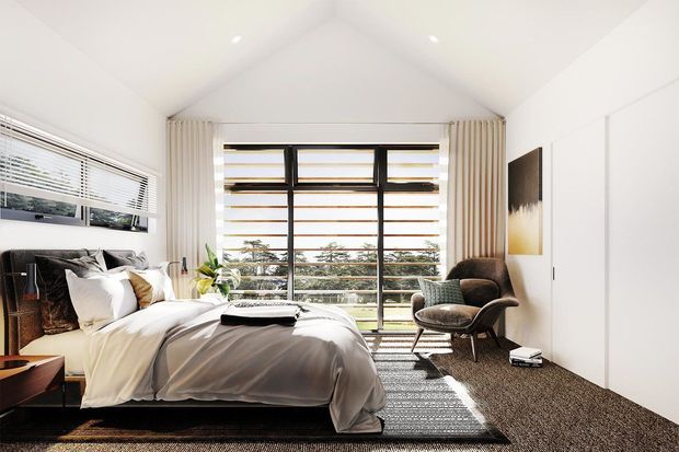 Bright contemporary bedroom with a vaulted white ceiling, large black-framed horizontal windows, layered curtains, a low upholstered bed with white bedding, bedside furniture, a lounge chair, and textured carpeting. The room has abundant natural light and a restrained neutral palette.