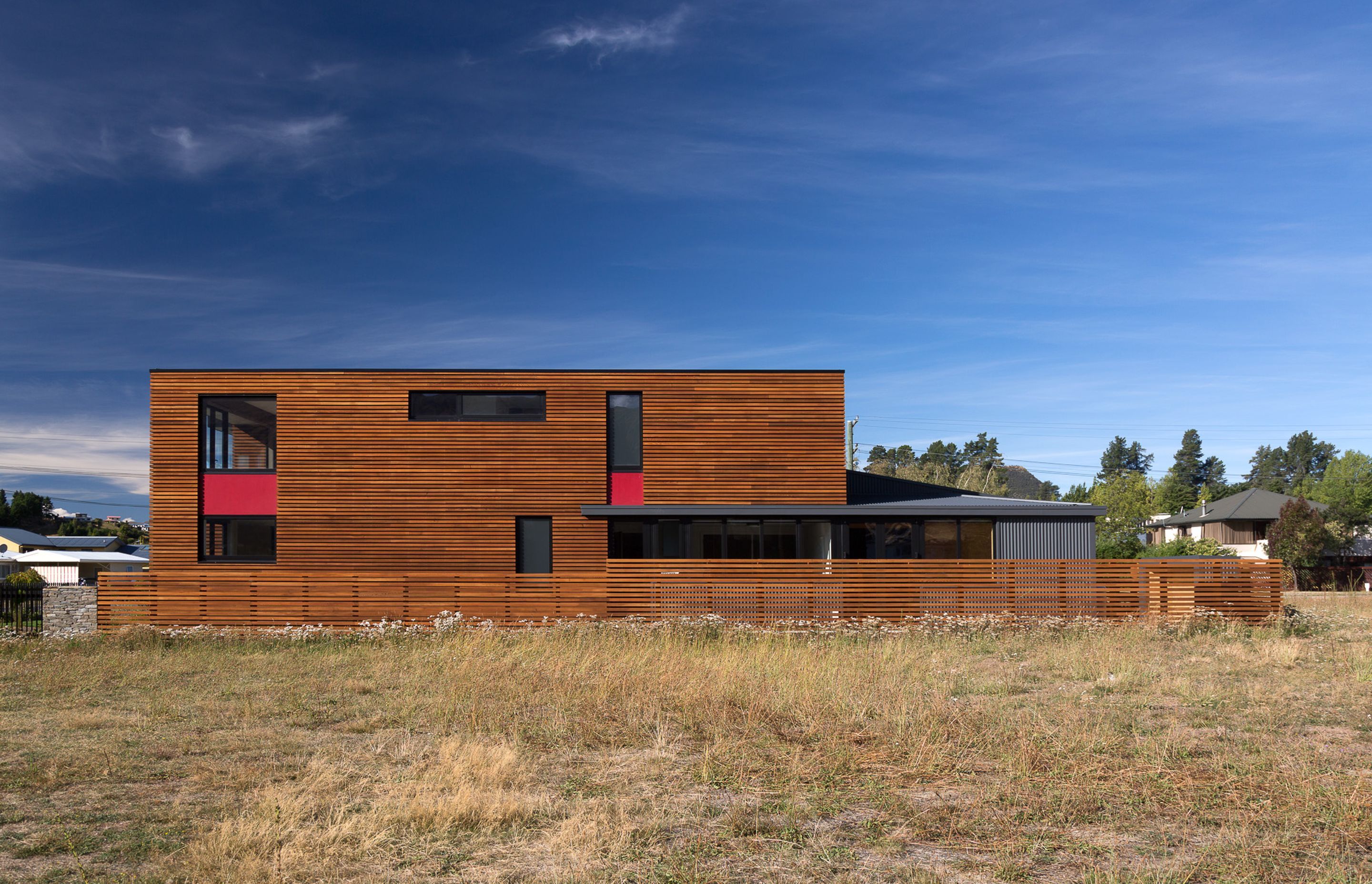 While the majority of the house is clad in horizontal cedar battens, details such as the window frames, flashing and chimney caps are in black metal with ‘pops’ of red—a nod to the De Stijl school of design..