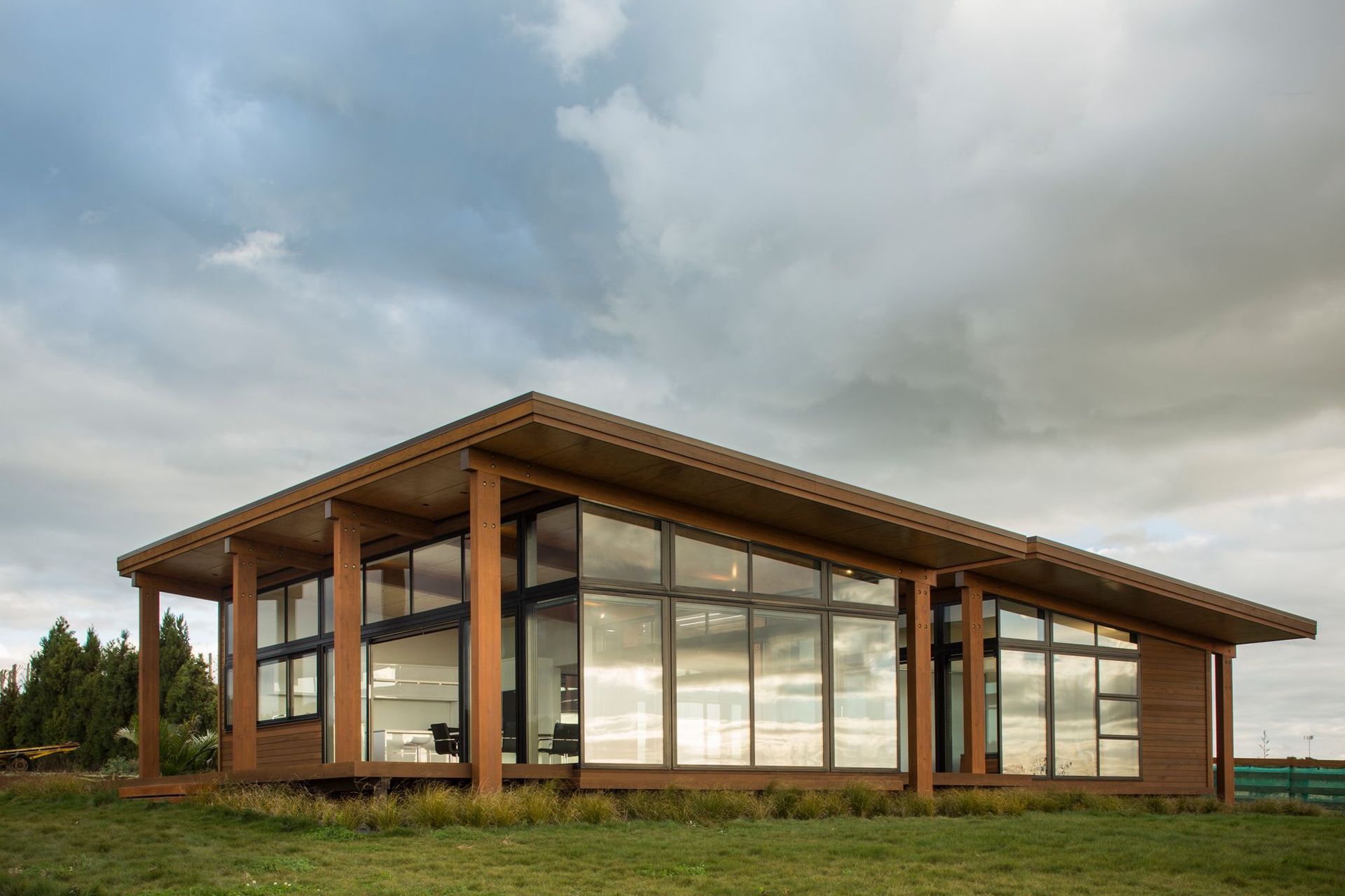 Macrocarpa rain screen and Cedar weatherboards are broken up with expansive full height glazing overlooking the surrounding landscape.