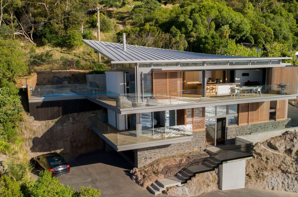 Red Rock House by Borrmeister Architects was designed to provide shelter from the prevailing winds, incorporate natural cross ventilation, solar panels, rainwater retention tanks and an ultra-low emission logburner.