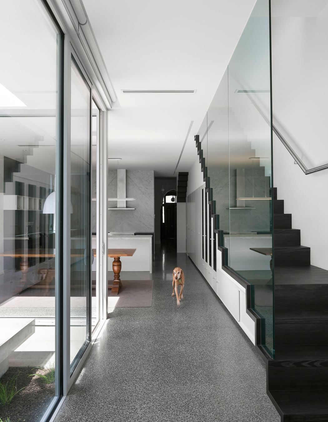 Cool-hued natural stone, exposed agriculture, polished concrete, dark-stained timber, and the clarity of double-glazed glass.