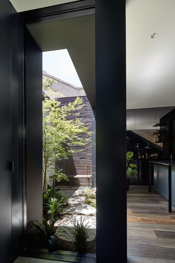 The ground floor addition embraces a bold aesthetic – all grey-tinted mirrors and dark walls, expanding the interior visually while cleverly disguising the compactness of the property.