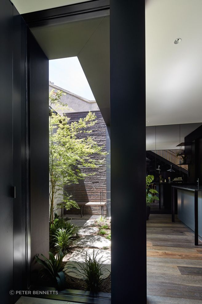 The ground floor addition embraces a bold aesthetic – all grey-tinted mirrors and dark walls, expanding the interior visually while cleverly disguising the compactness of the property.