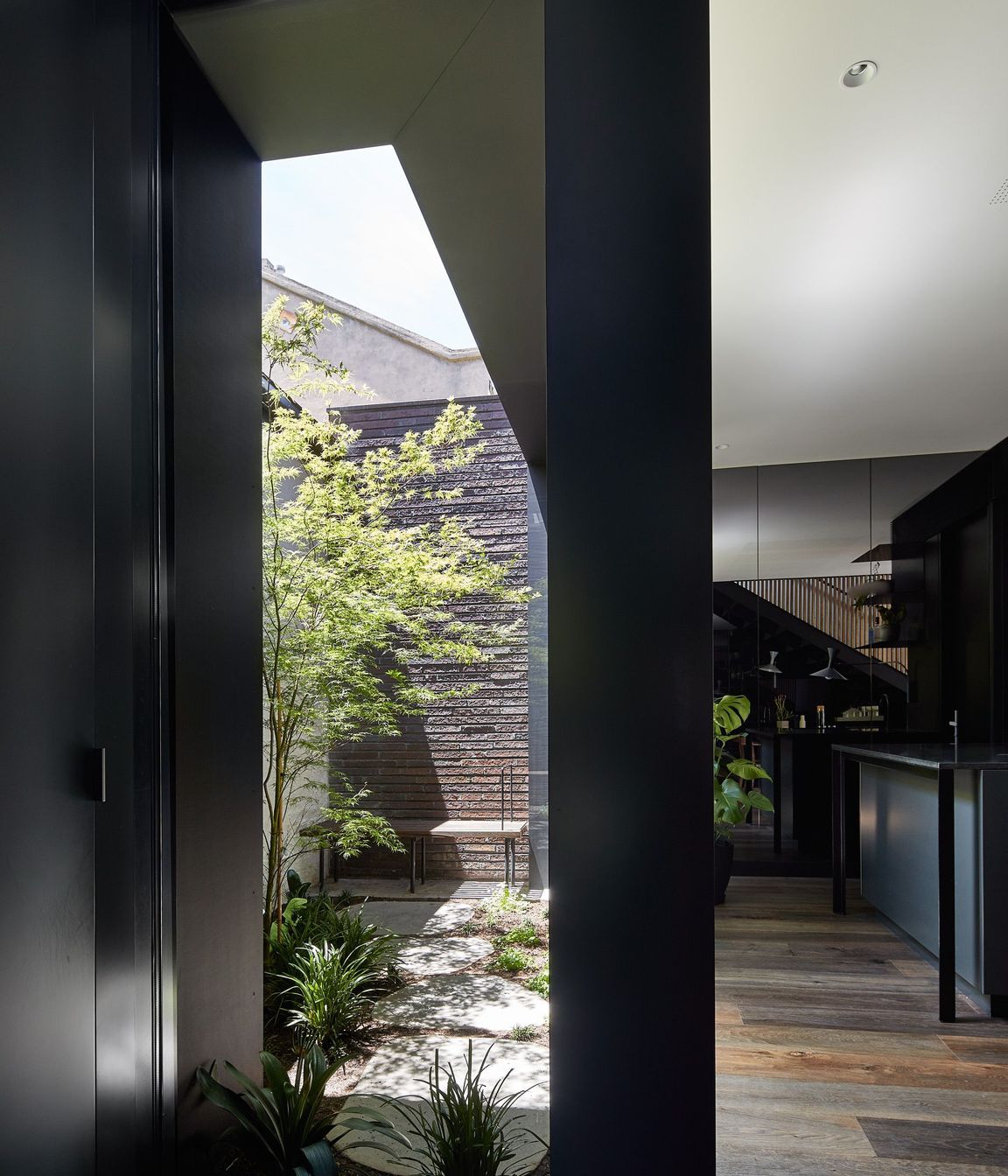 The ground floor addition embraces a bold aesthetic – all grey-tinted mirrors and dark walls, expanding the interior visually while cleverly disguising the compactness of the property.