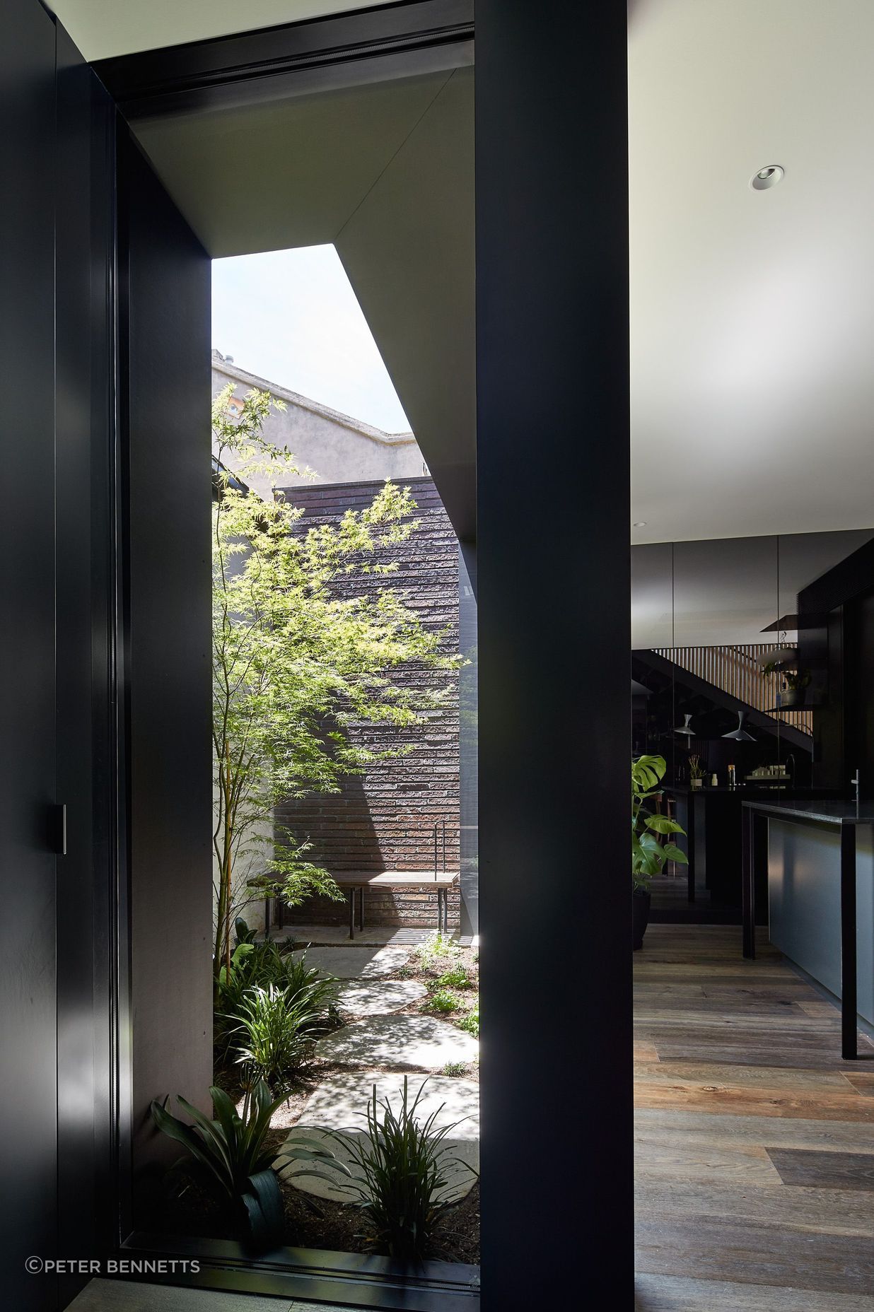 The ground floor addition embraces a bold aesthetic – all grey-tinted mirrors and dark walls, expanding the interior visually while cleverly disguising the compactness of the property.