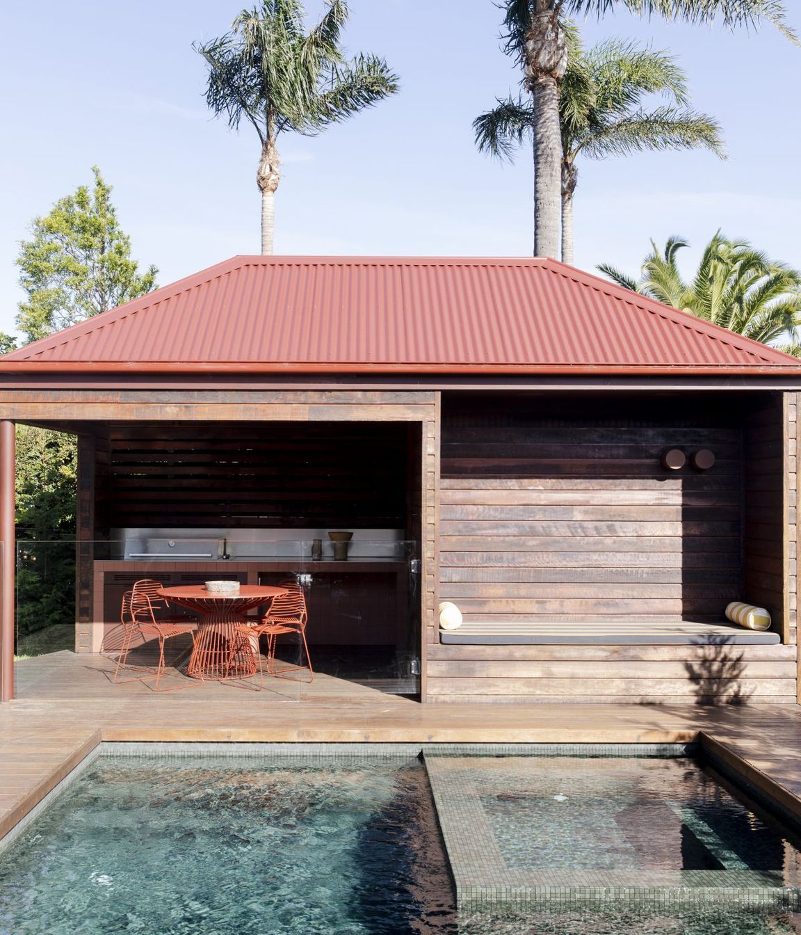 An outdoor entertainment space draws one toward cooling waters.