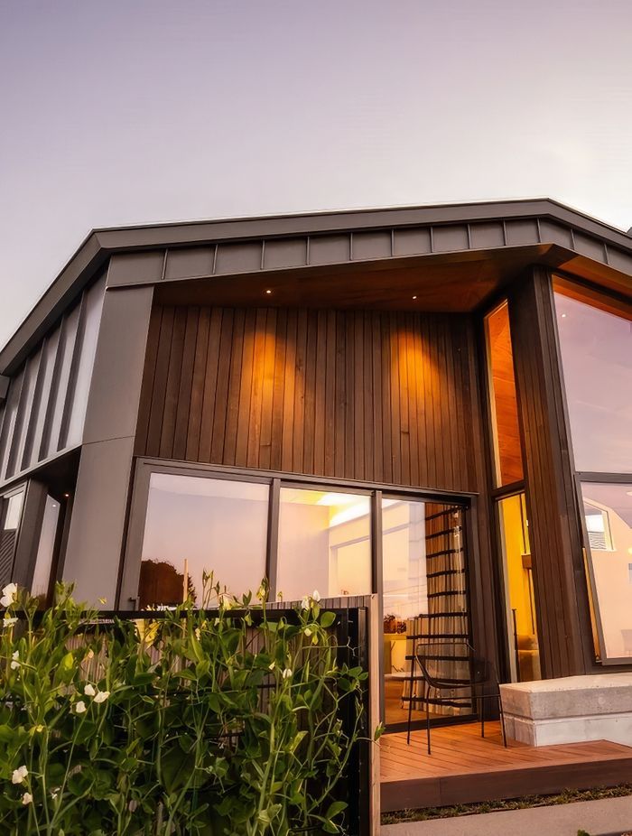 The facade features cedar cladding and aluminium standing seam roofing.