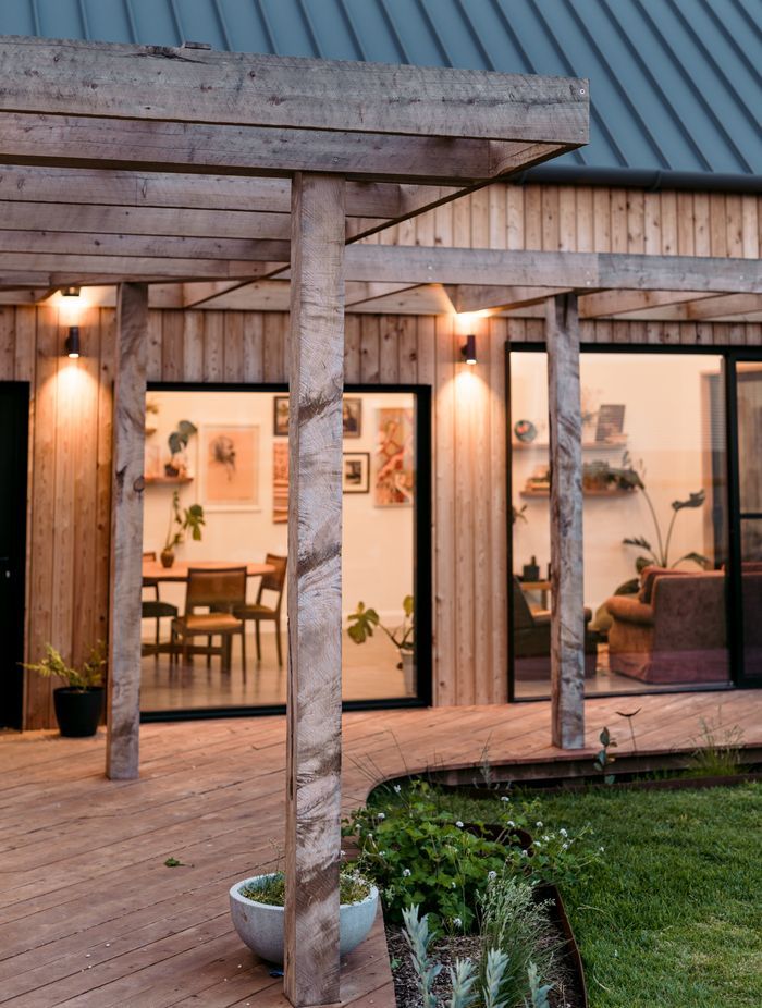 Large black framed windows connect the living zones to the outdoors.