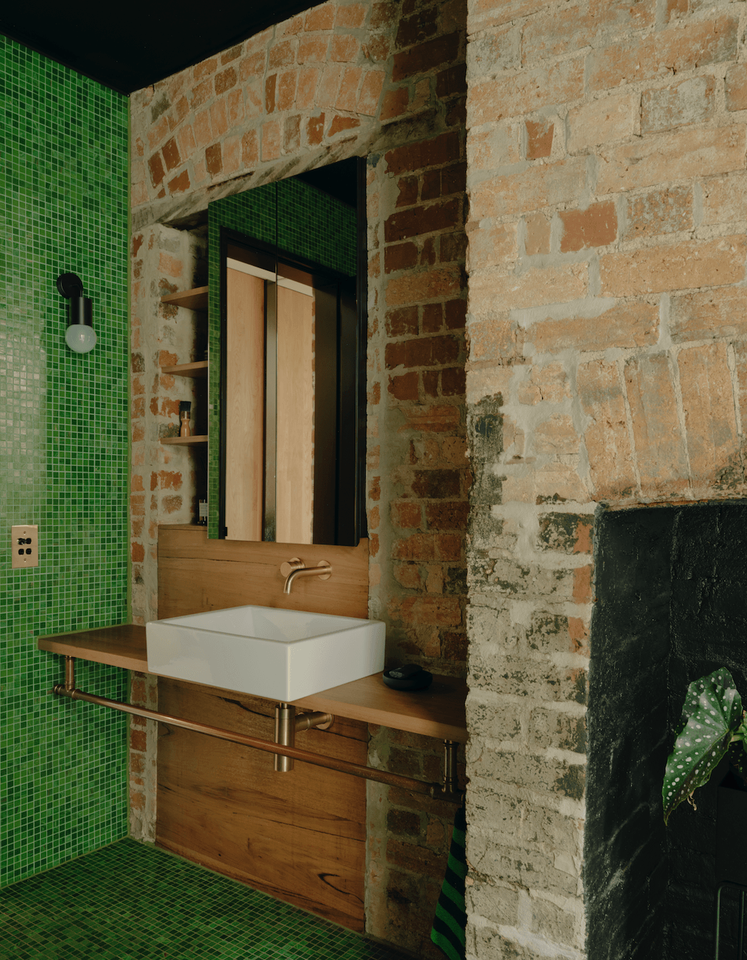 One element of the space is a particularly noteworthy design choice – a verdant green-tiled bathroom.