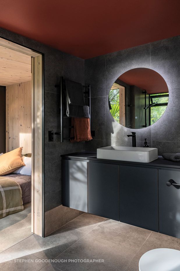 The en suite bathroom features moody tones, for a recessive look.