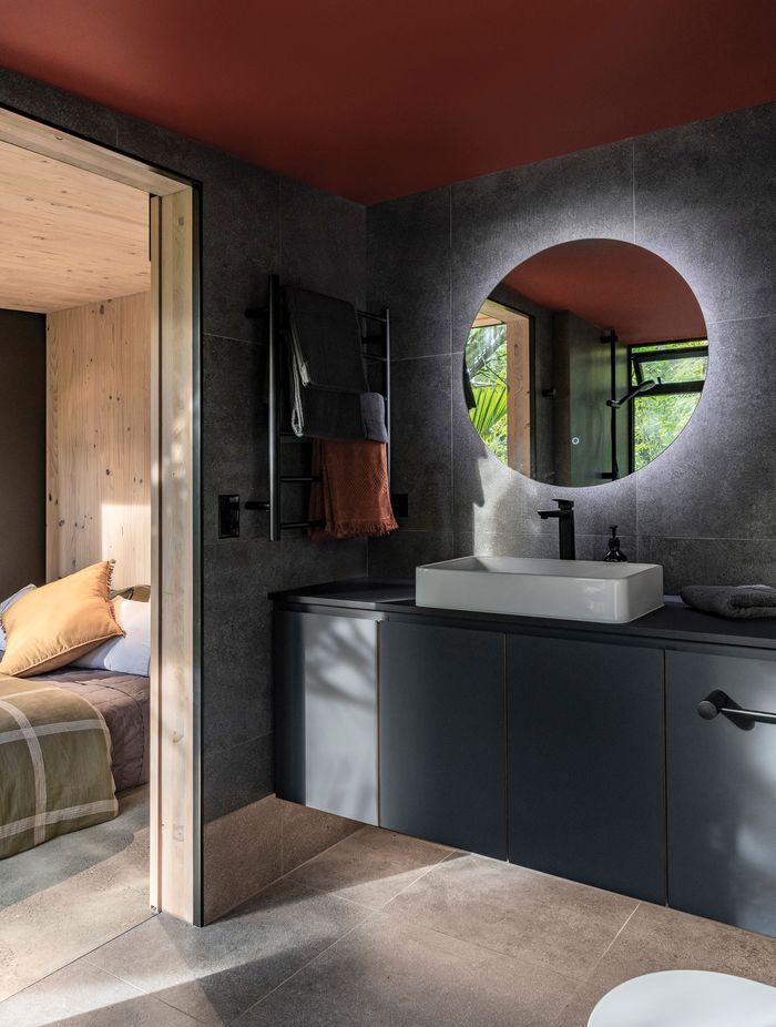 The en suite bathroom features moody tones, for a recessive look.