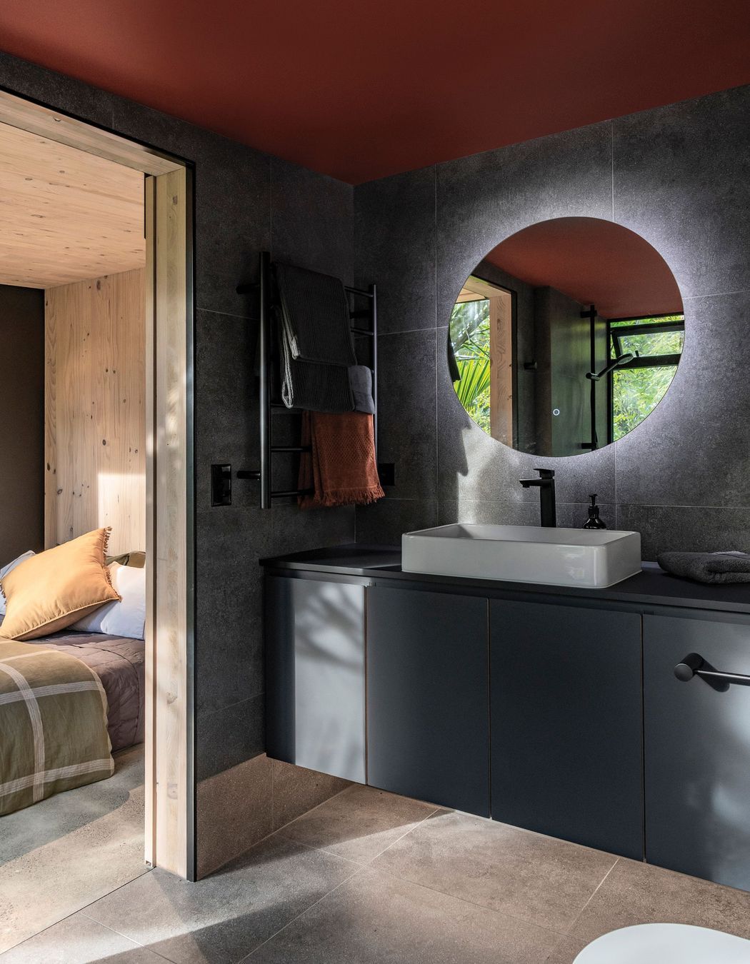 The en suite bathroom features moody tones, for a recessive look.