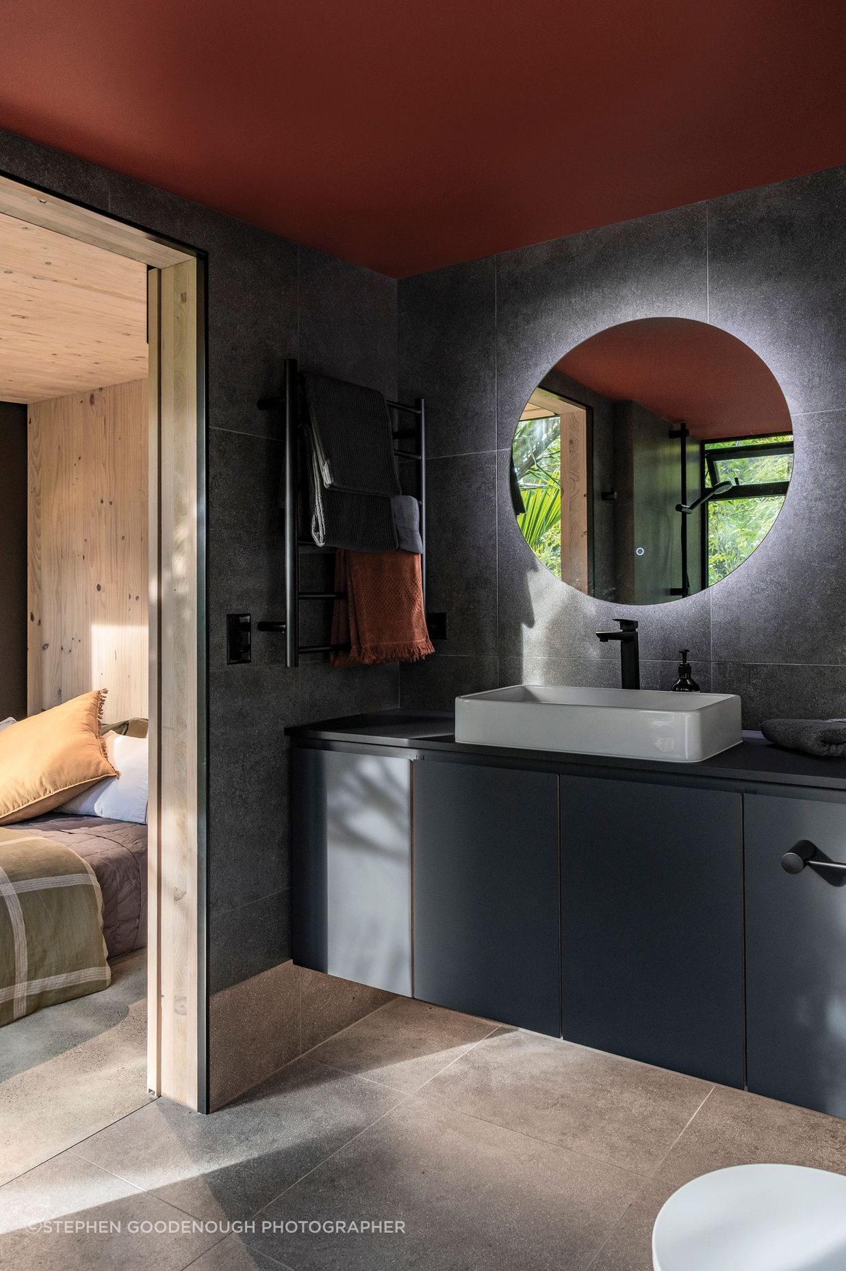 The en suite bathroom features moody tones, for a recessive look.