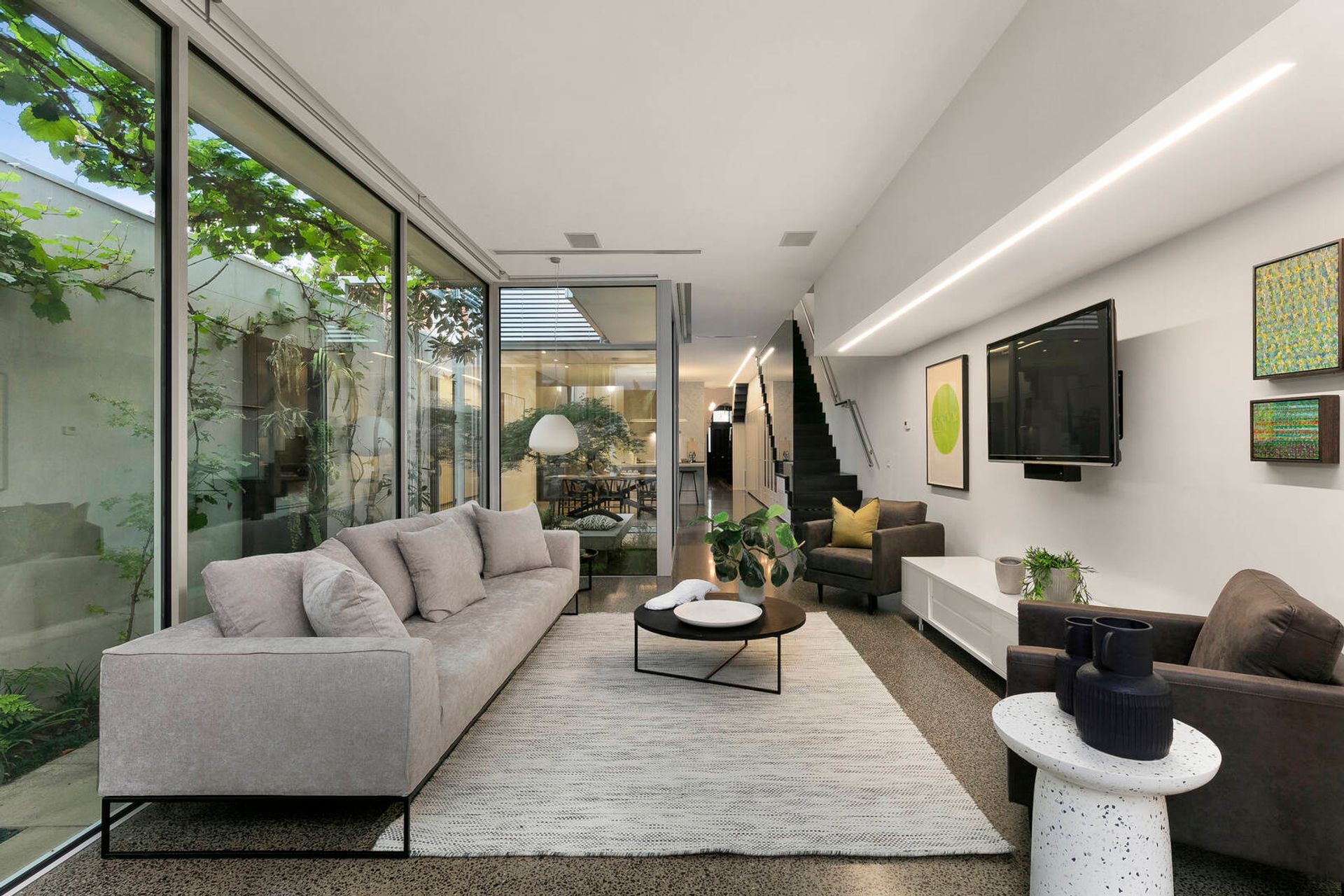 The striking space seamlessly integrates the old facade with a sleek glass- and concrete-laden open-plan extension.