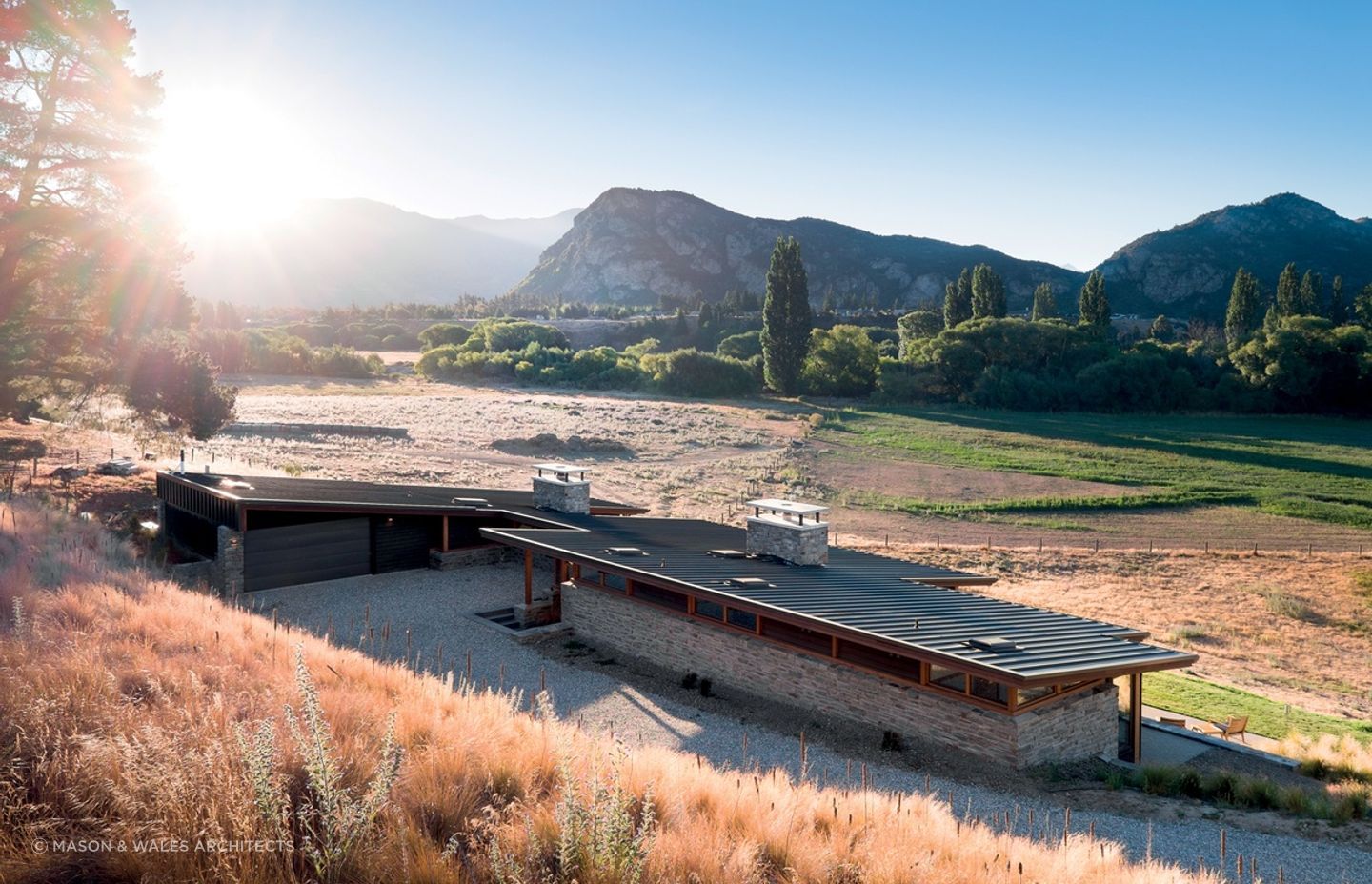 The distinctive sharp, sloping roof and two large schist chimneys of the Cardrona River House by Mason & Wales Architects are great features of this impressive home. | Photography: Dennis Radermacher