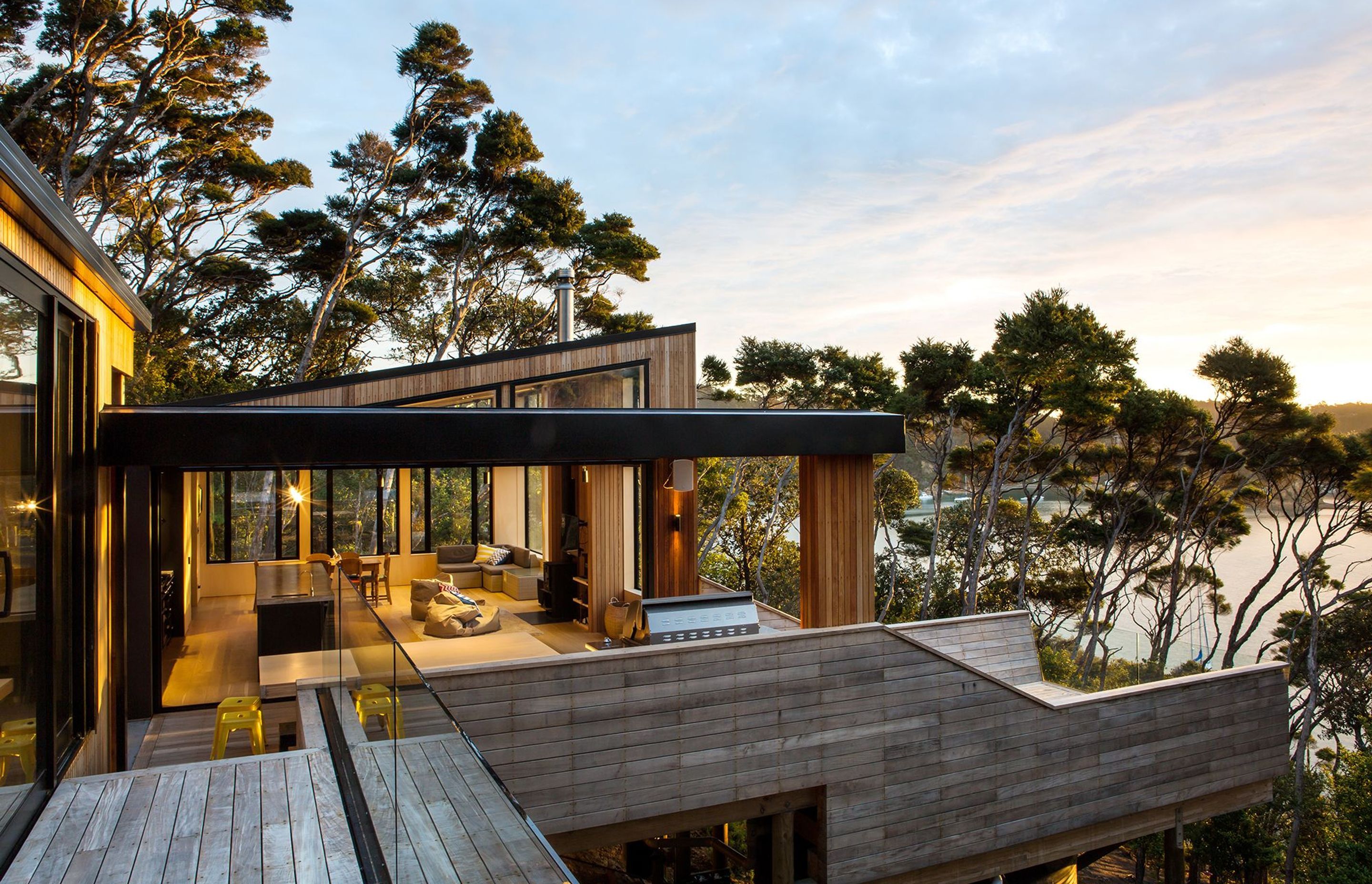 The form of Dorrington Atcheson Architects' Kawau House, hunkers into a steep manuka-clad site, following the contours of the hillside. Photograph by Emma-Jane Hetherington.