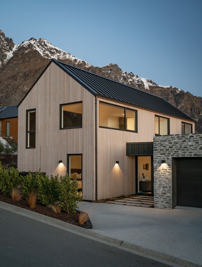 The minimal exterior showcasing vertical shiplap timber and Glenorchy schist.